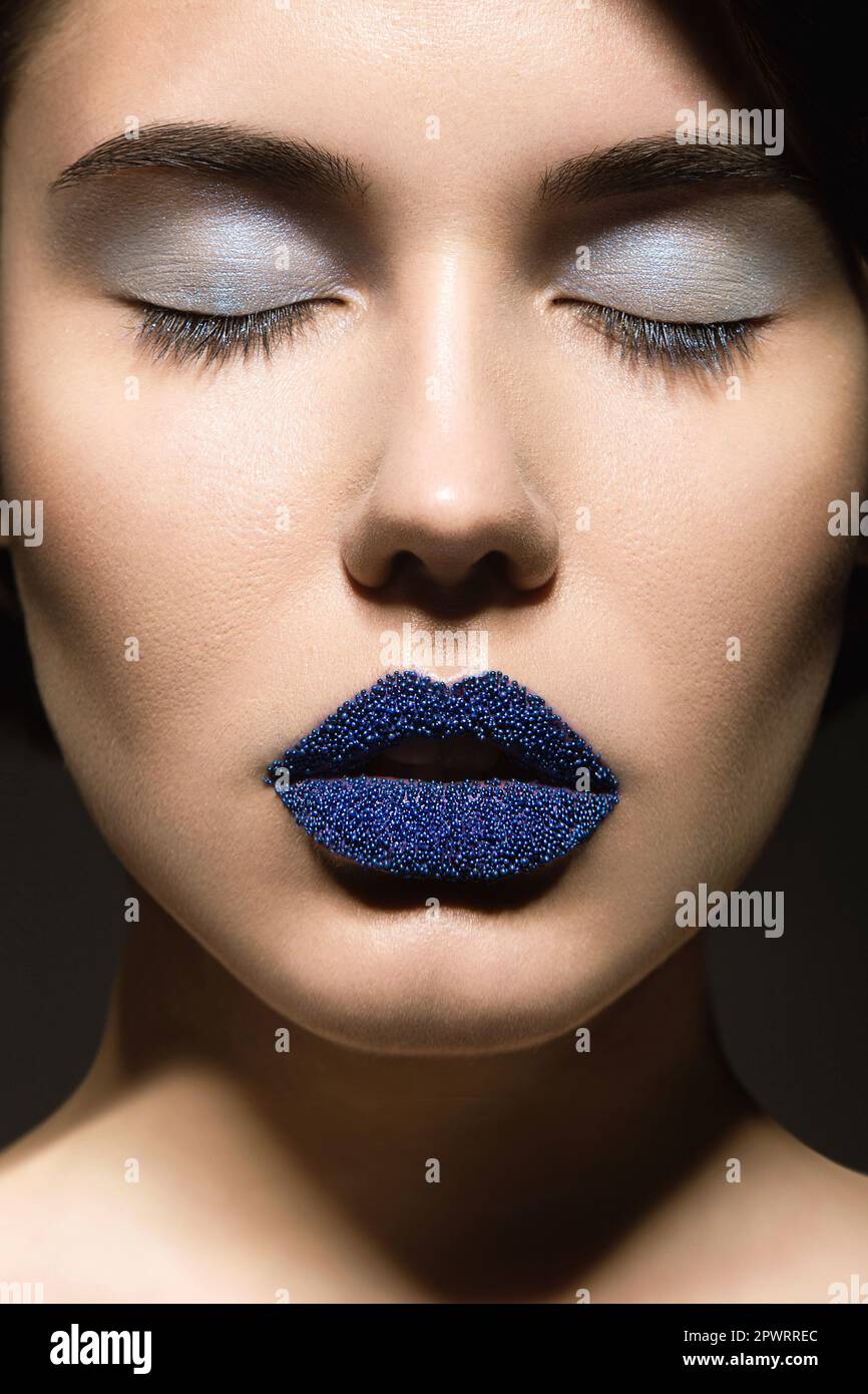 Portrait of beautiful girl with unusual blue lips and eyes closed
