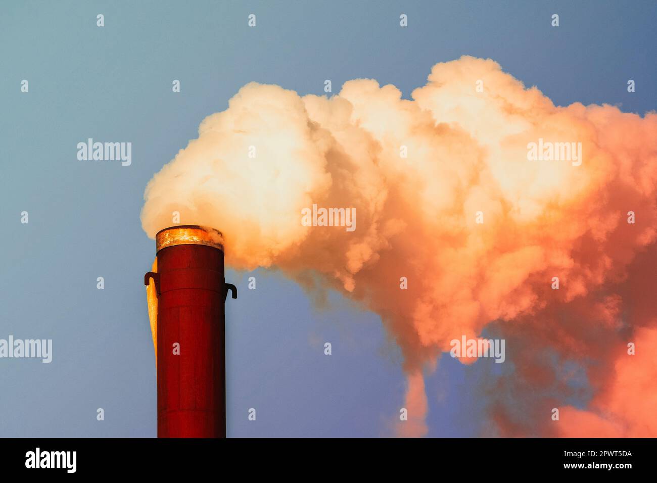 Thick and heavy orange smoke coming out of a chemical factory chimney ...