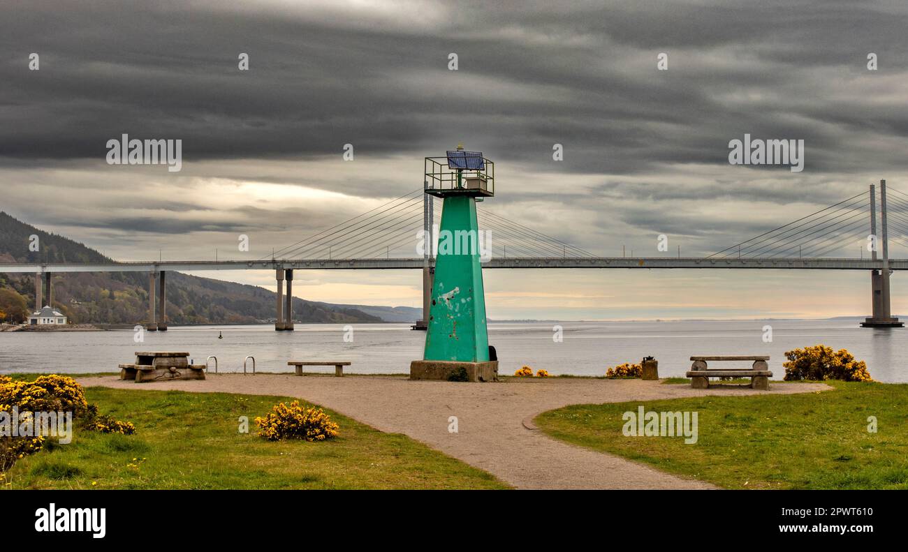 Inverness Scotland green lighthouse at Carnac Point and a view of the Kessock Bridge Stock Photo
