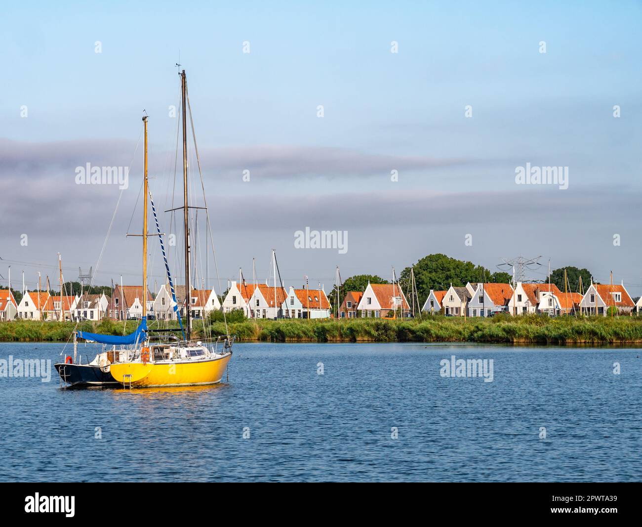 Skyline of row of houses and dike of Durgerdam village from Buiten IJ river near Amsterdam, Netherlands Stock Photo