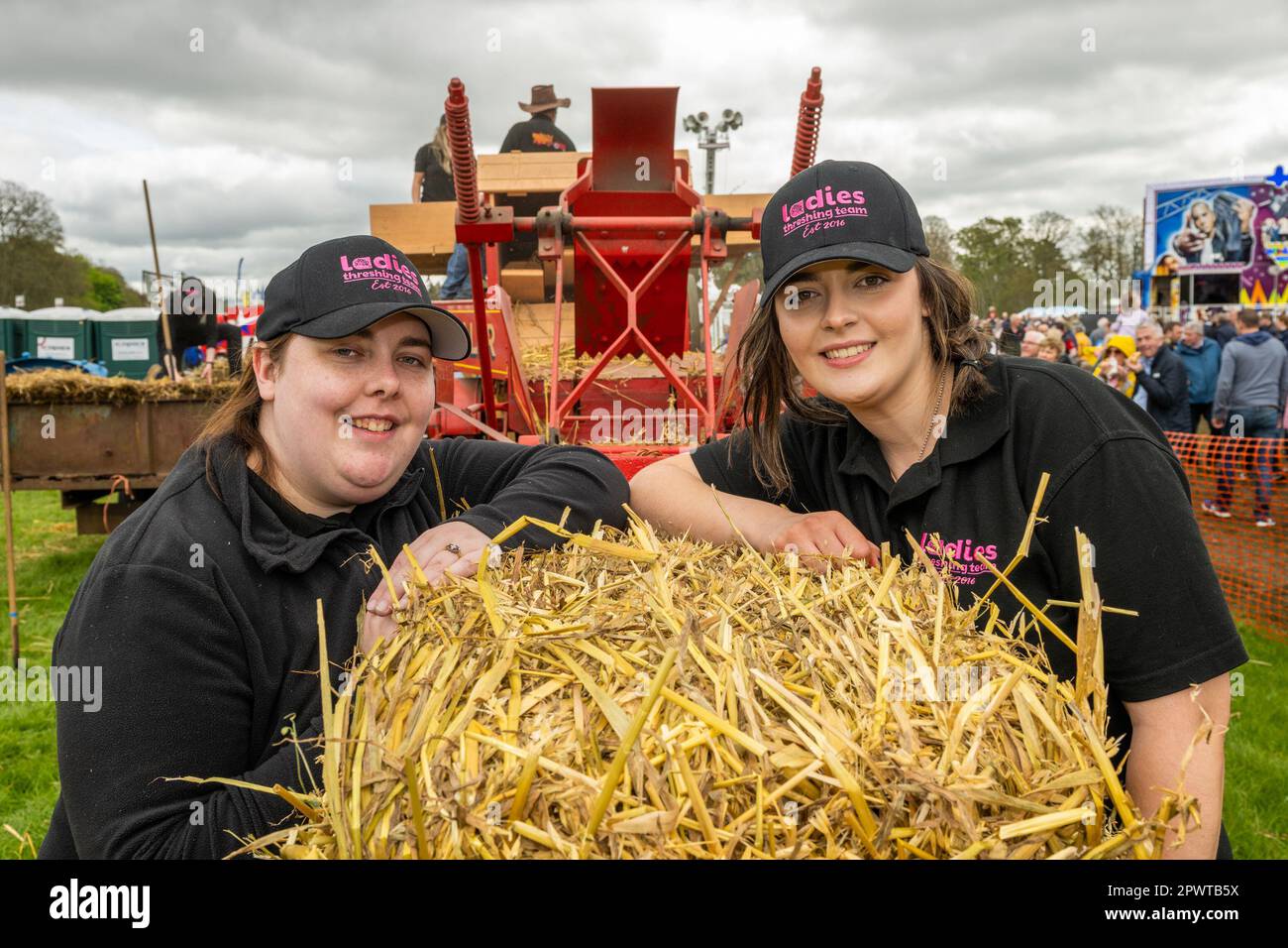 Antrim, N. Ireland. 1st May, 2023. The Shanes Castle Steam Rally took place on Sun 30th Apr and Mon 1st May and attracted thousands of people. Steam Traction Engines, tractors, a fun fair, classic cars and birds of prey demonstrations were just a few of the attractions. Tying the bales of straw as part of the Ladies Threshing Team were Erin Bell and Tara McLure. Credit: AG News/Alamy Live News Stock Photo