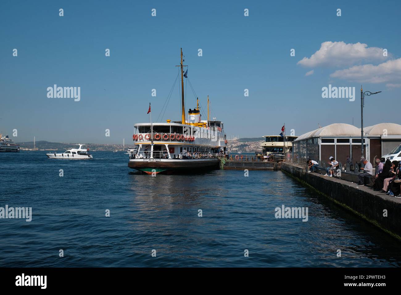 Istanbul, Turkey - May, 2022. Ferry boat on sea with buildings in background against sky with Galata Bridge at Istanbul, Turkey Stock Photo