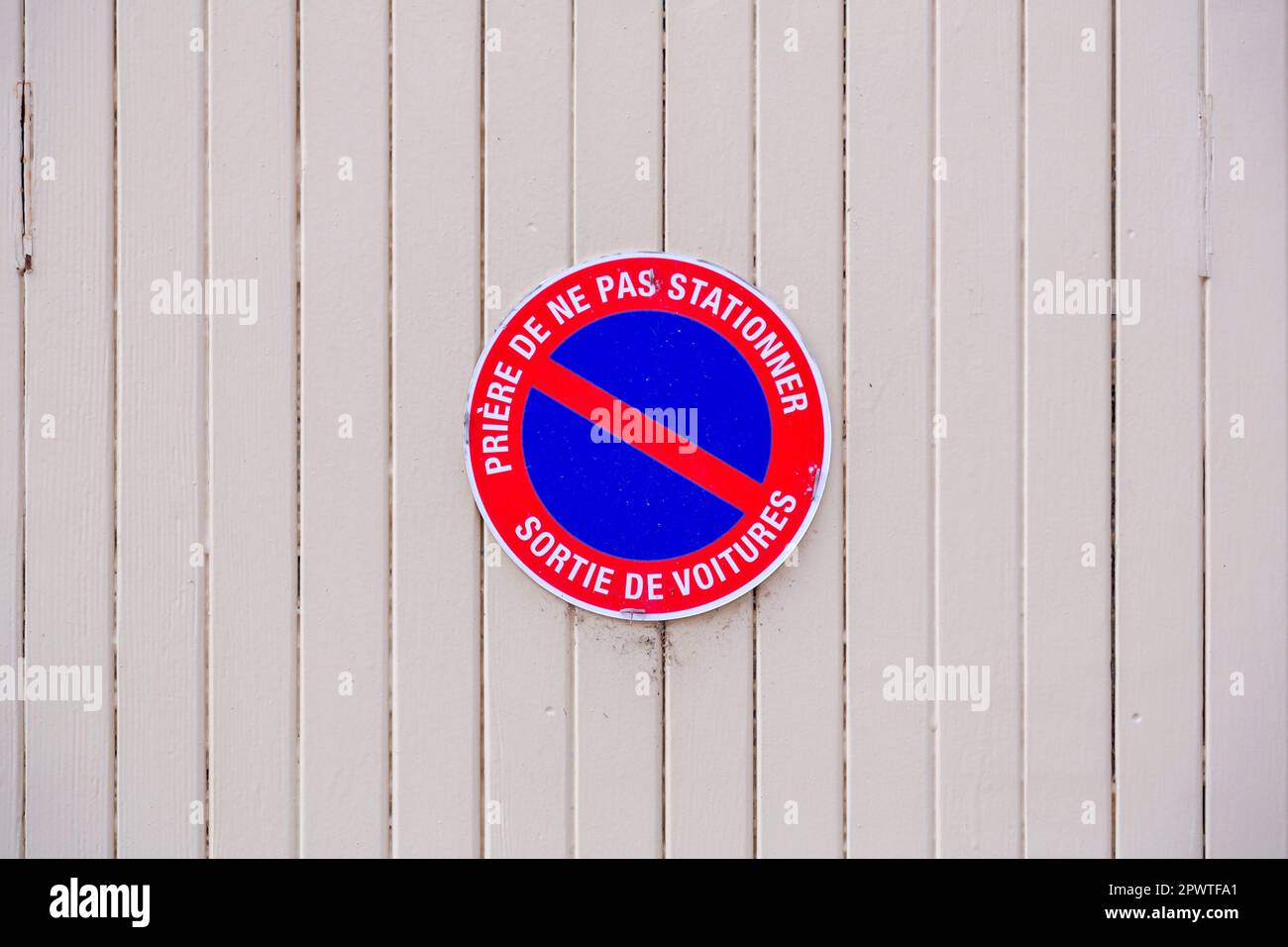 French 'Defense De Stationner - Sortie De Voitures' (No Parking - Car Exit)  sign on garage doors Stock Photo - Alamy