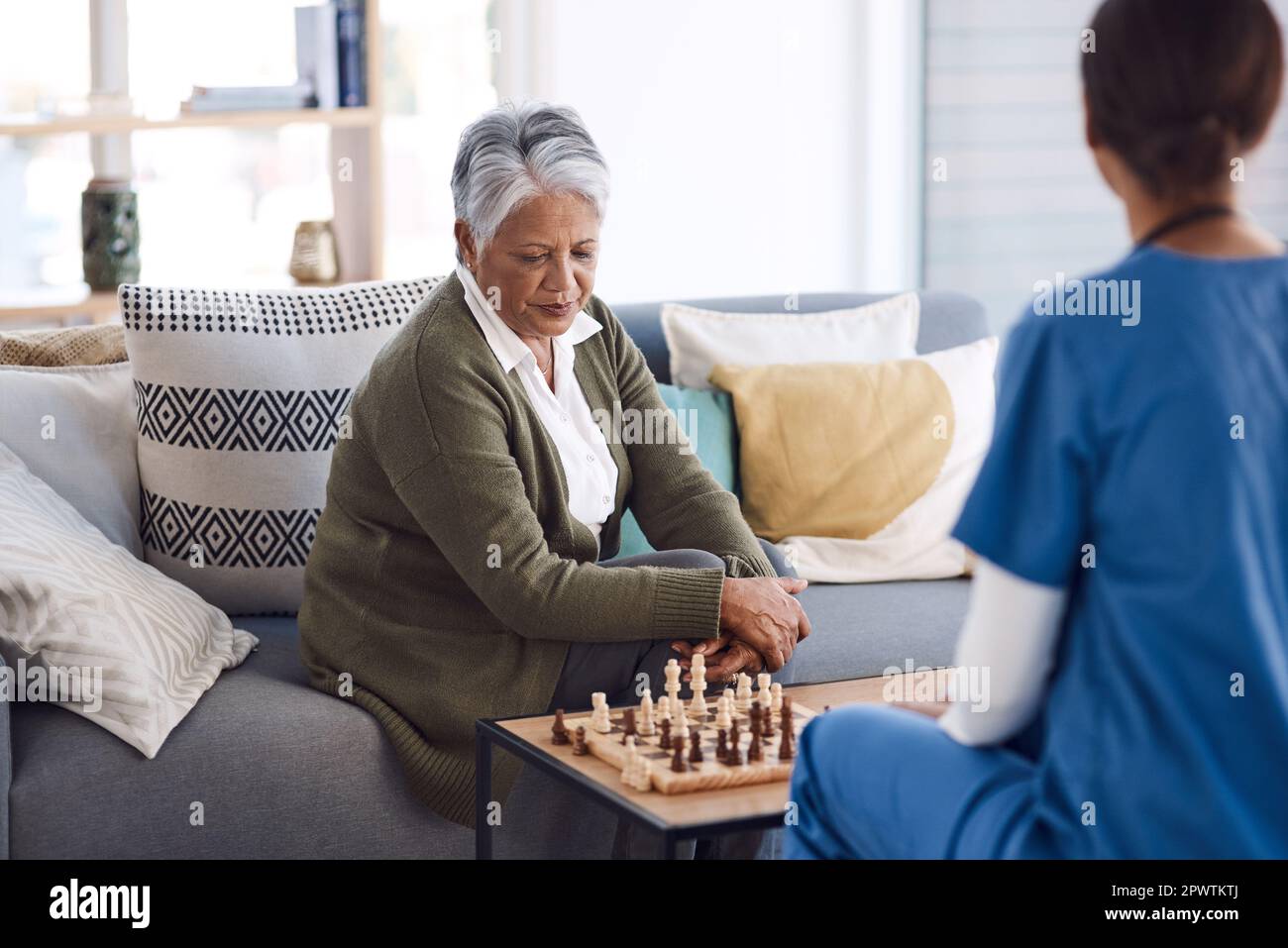 Woman playing chess thinking of next move Stock Photo - Alamy