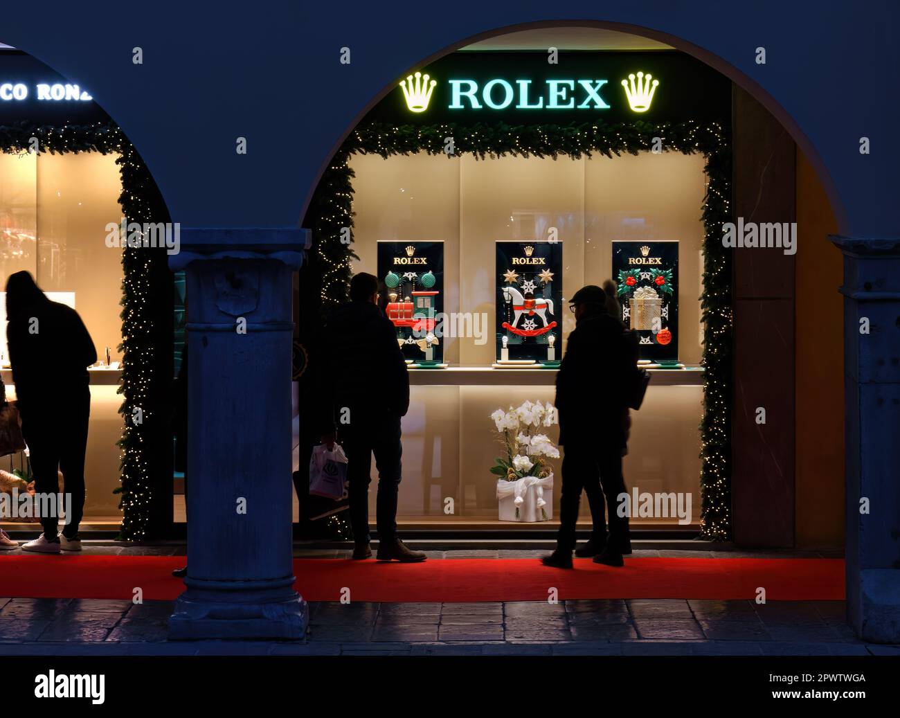 UDINE, Italy - December 8, 2022: People in front of the display windows of Rolex Store in Mercatovecchio street decorated in a Christmas theme Stock Photo