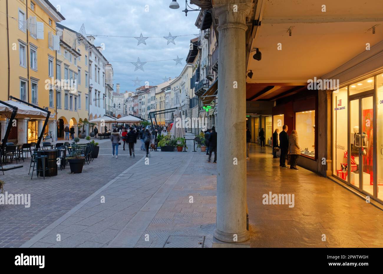 UDINE, Italy - December 8, 2022: City life in Mercatovecchio street in a winter evening Stock Photo