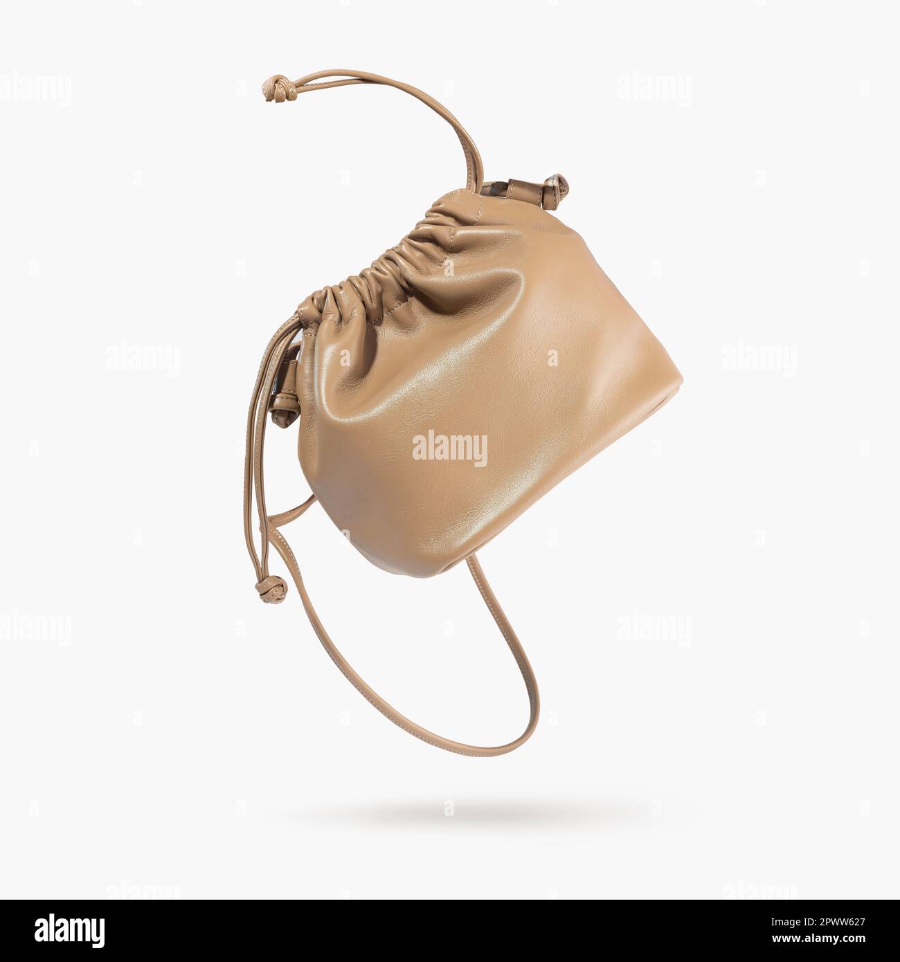 A brown female handbag with straps flying on a gray background. Minimalistic layout with bag. Advertising for ladies store, blog. Trendy accessories Stock Photo