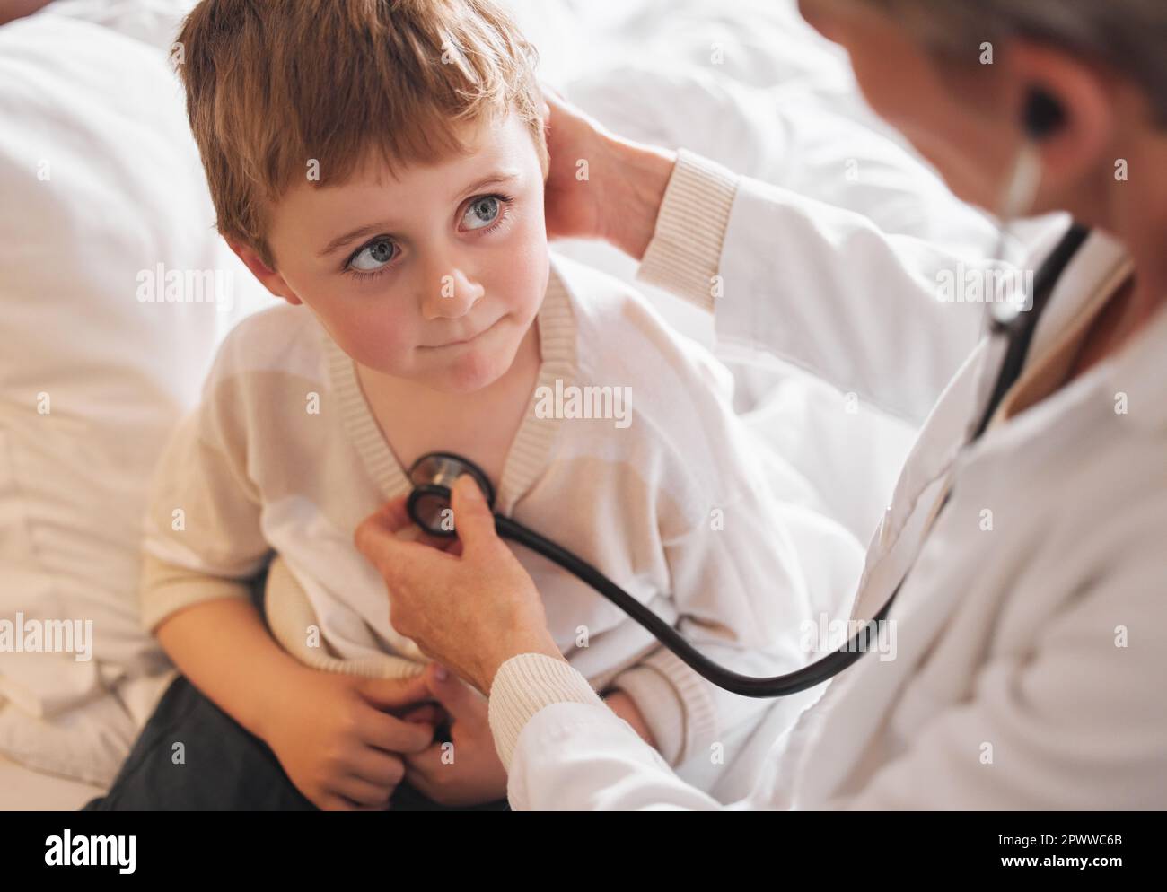 Lets hear whats happening in that chest. a doctor examine a little boy