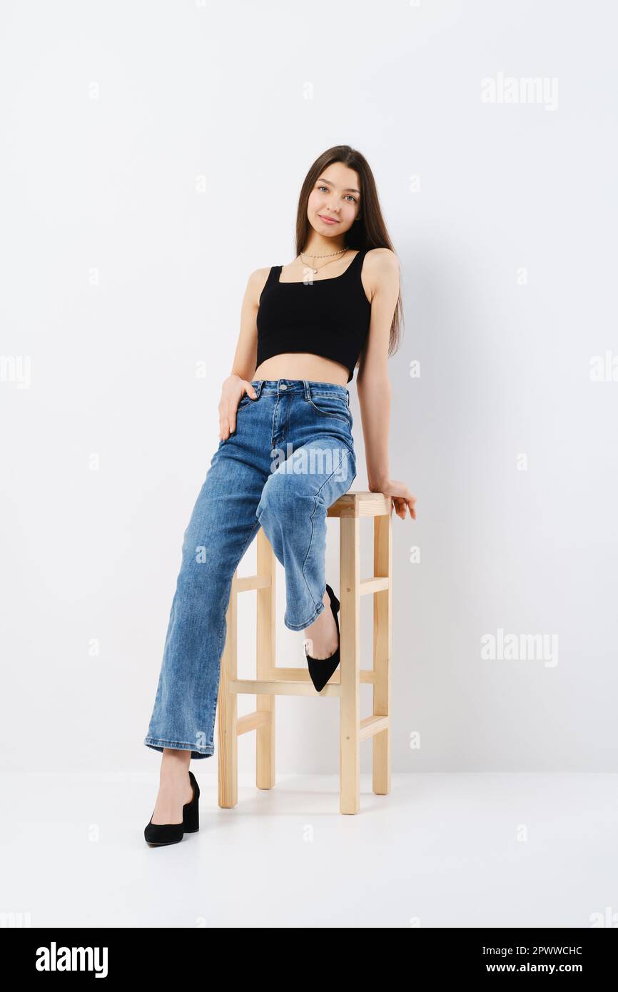 Full length portrait of relaxed young woman in black tank top and wide ...