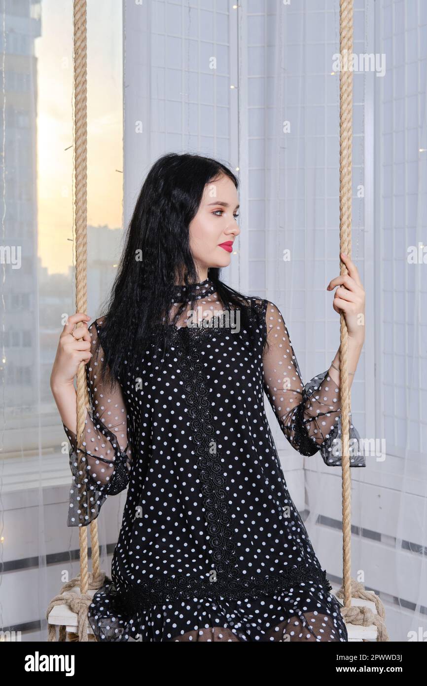 Pretty young woman having fun at home, swinging on swing Stock Photo ...