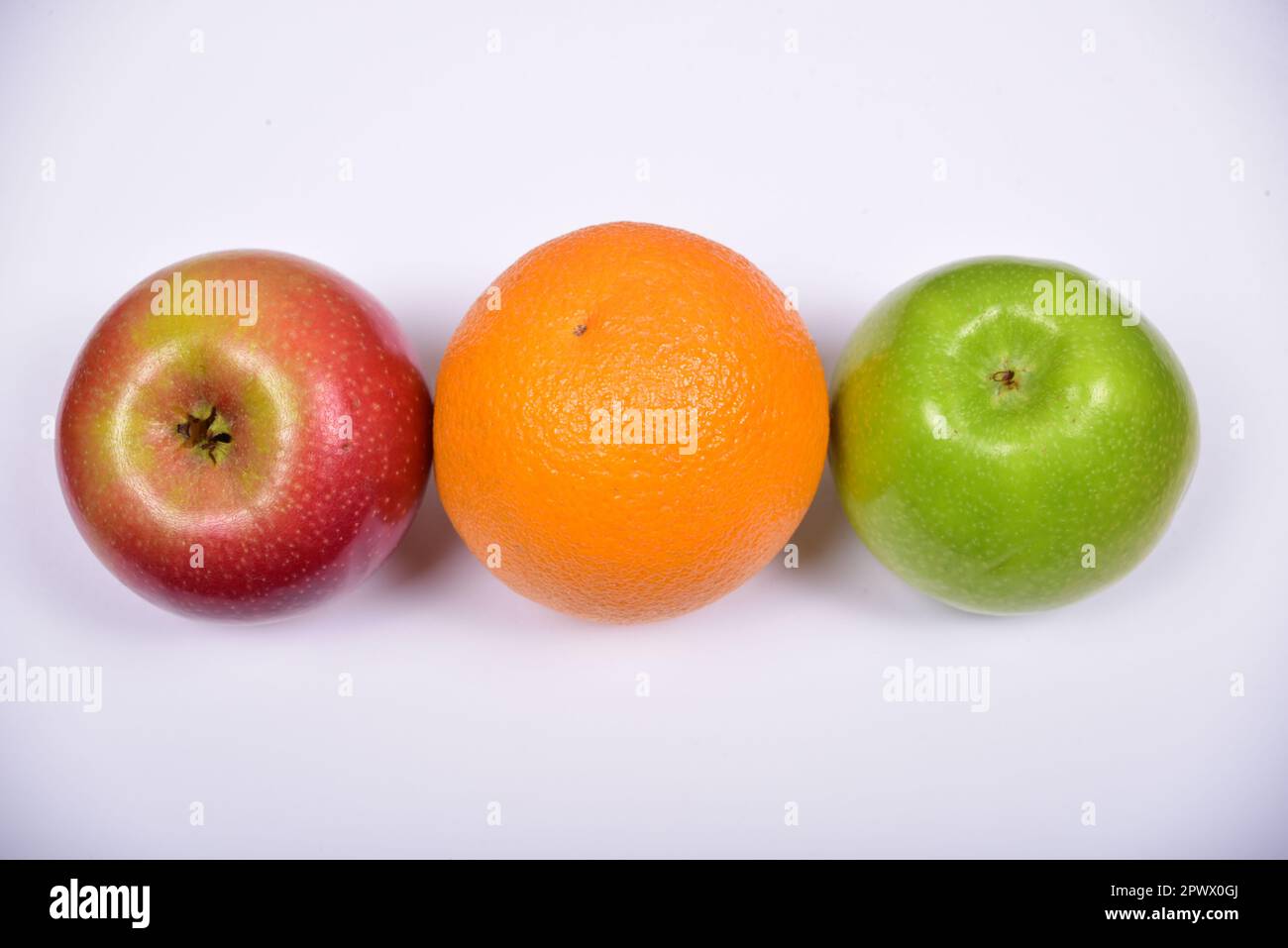 red apple, orange and green apple on an isolated background Stock Photo ...