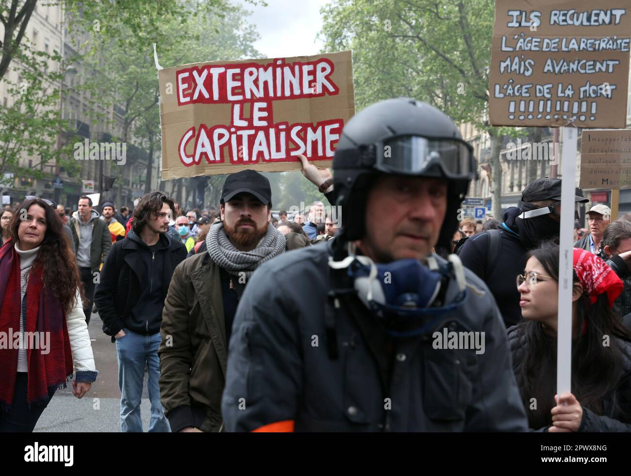 Paris, France. 01st May, 2023. Demonstrators hold anti-capitalism placards during a Labor Day mass protest in the streets of Paris, on Monday, May 1, 2023. Clashes erupted between security forces and radical protesters smashing bank windows as unions pushed the president to scrap a higher retirement age. Photo by Maya Vidon-White/UPI Credit: UPI/Alamy Live News Stock Photo