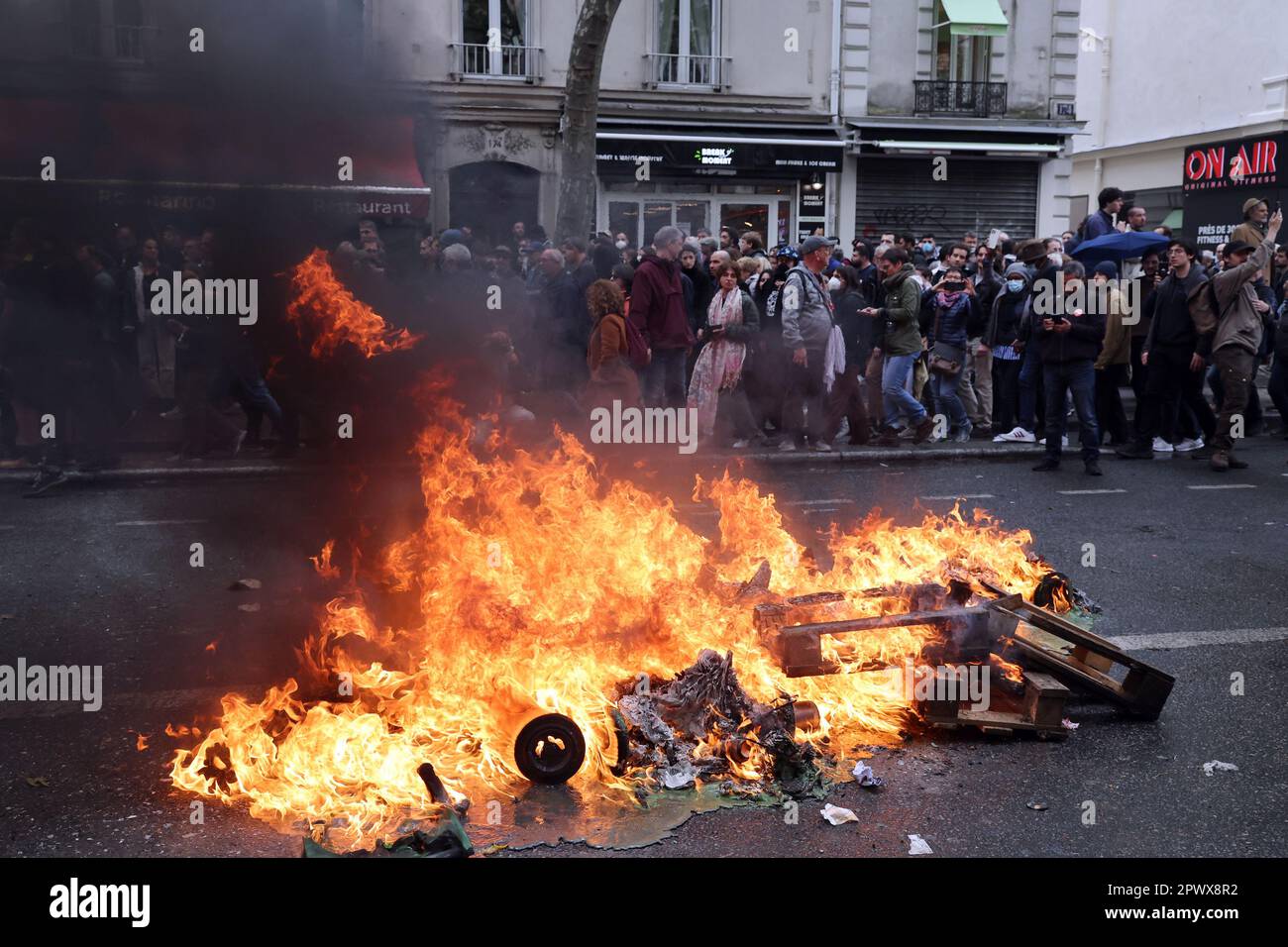 Paris, France. 01st May, 2023. Demonstrators walk past burning garbage during a Labor Day mass protest in the streets of Paris, on Monday, May 1, 2023. Clashes erupted between security forces and radical protesters smashing bank windows as unions pushed the president to scrap a higher retirement age. Photo by Maya Vidon-White/UPI Credit: UPI/Alamy Live News Stock Photo