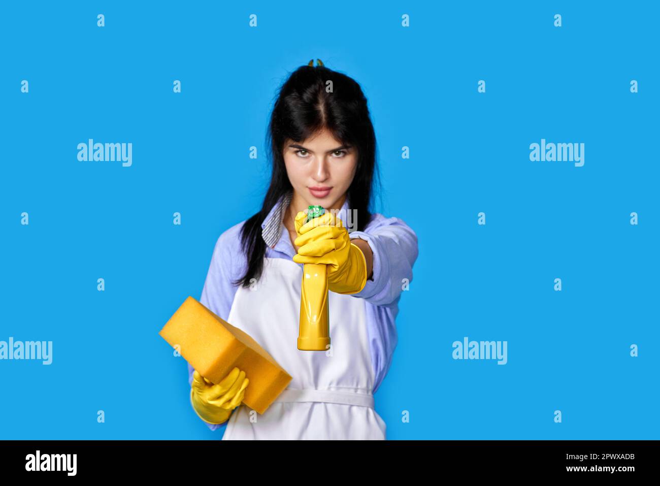 young confident woman in yellow rubber gloves and cleaner apron ...