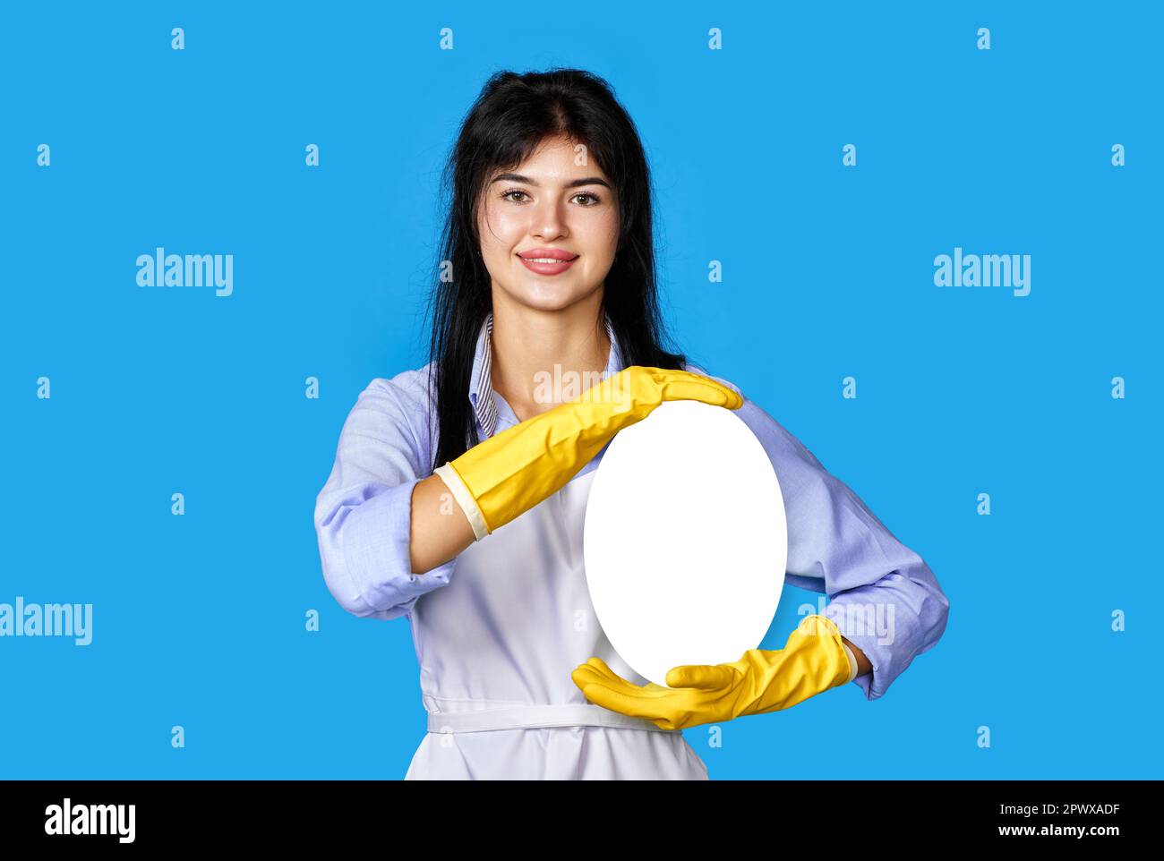 smiling woman in yellow rubber gloves and cleaner apron showing copy ...
