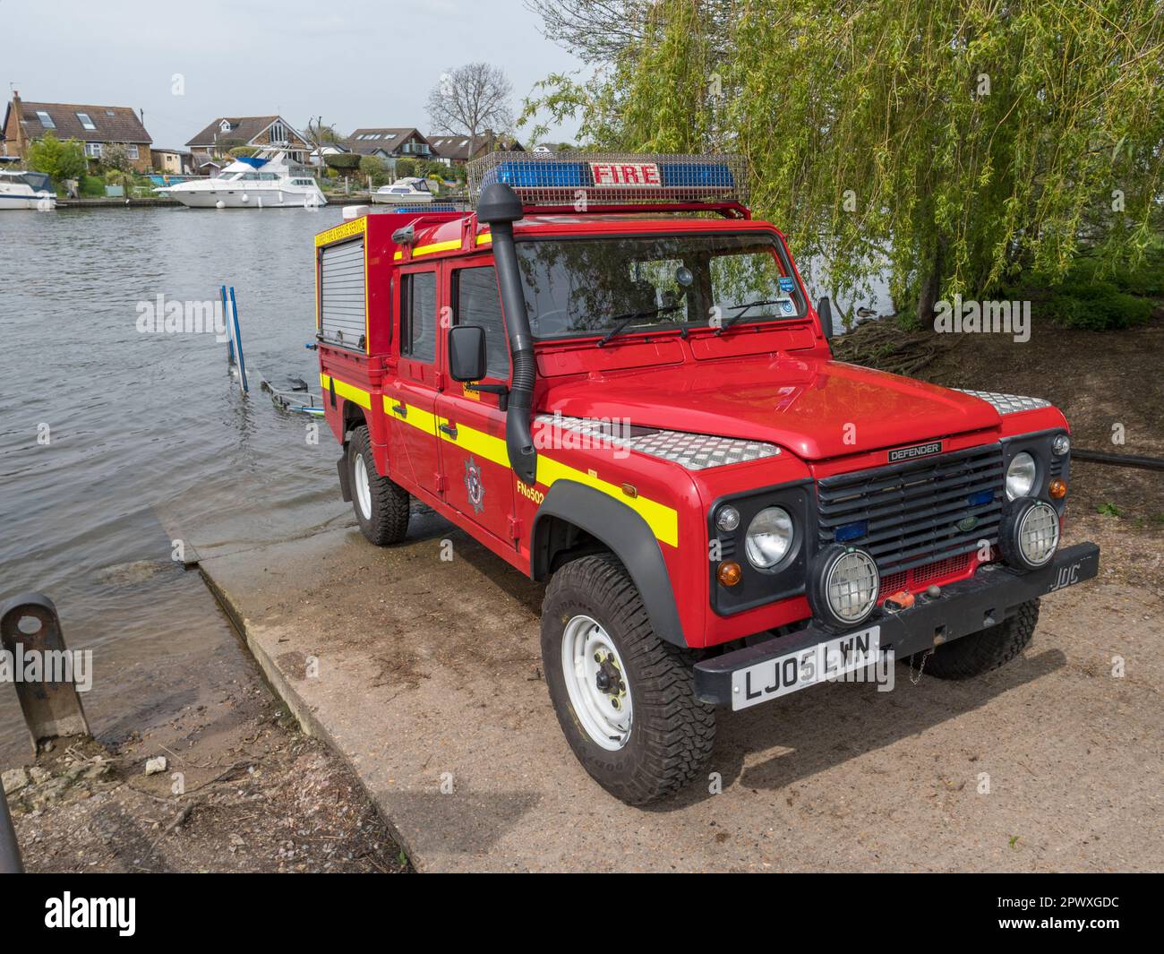 A Surrey Fire and Rescue Service Defender Land Rover on a boat slip (after launching a boat) beside the River Thames, Walton-on-Thames, Surrey, UK. Stock Photo
