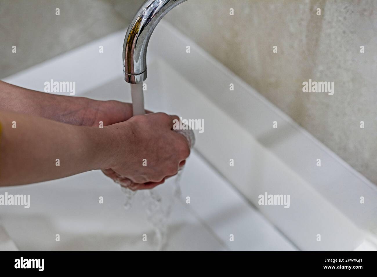 child washes his hands under the pressure of water from infections and