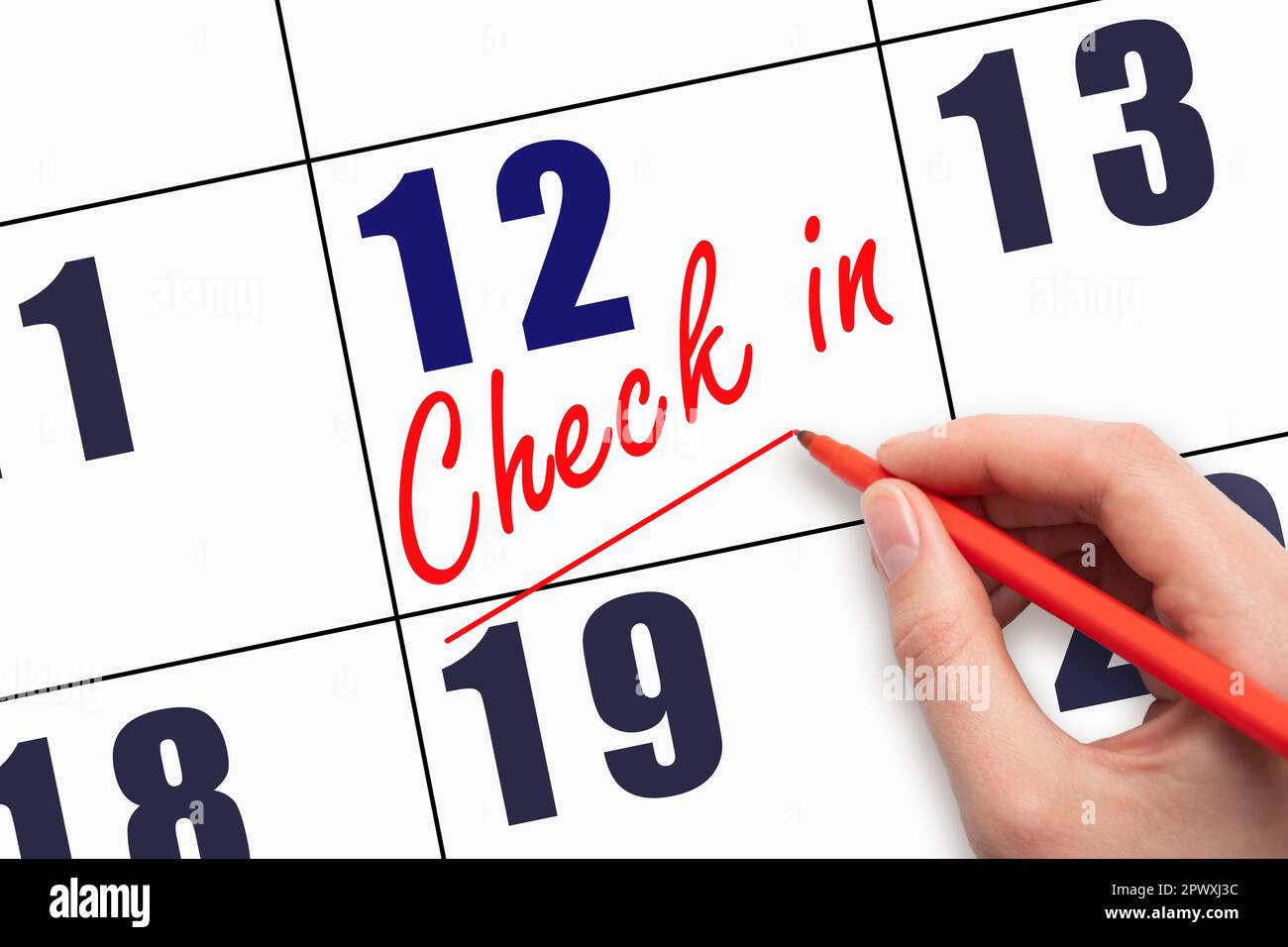 12th day of the month.  Hand writing CHECK IN and drawing a line on calendar date. Business.  Day of the year concept. Stock Photo