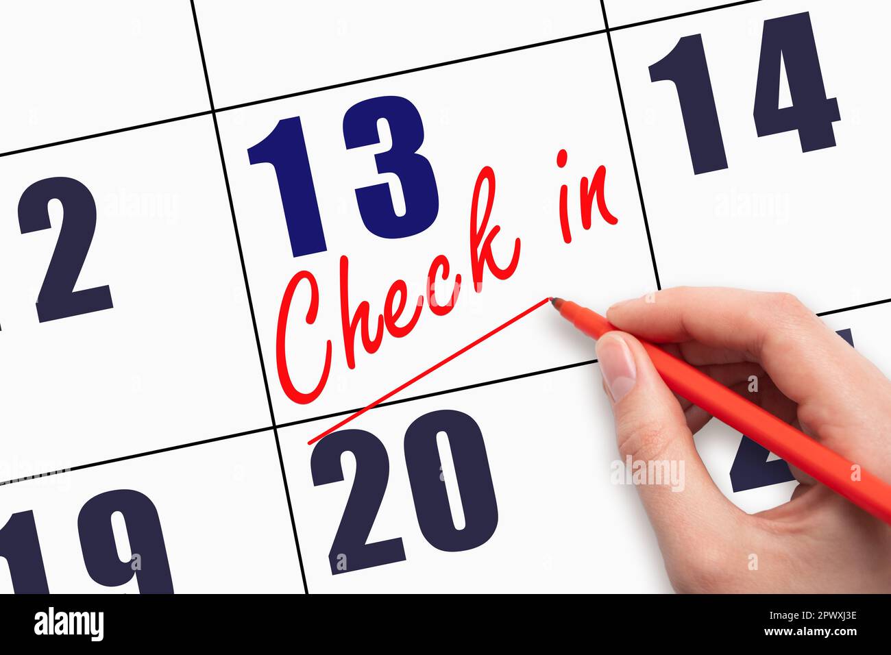 13th day of the month.  Hand writing CHECK IN and drawing a line on calendar date. Business.  Day of the year concept. Stock Photo
