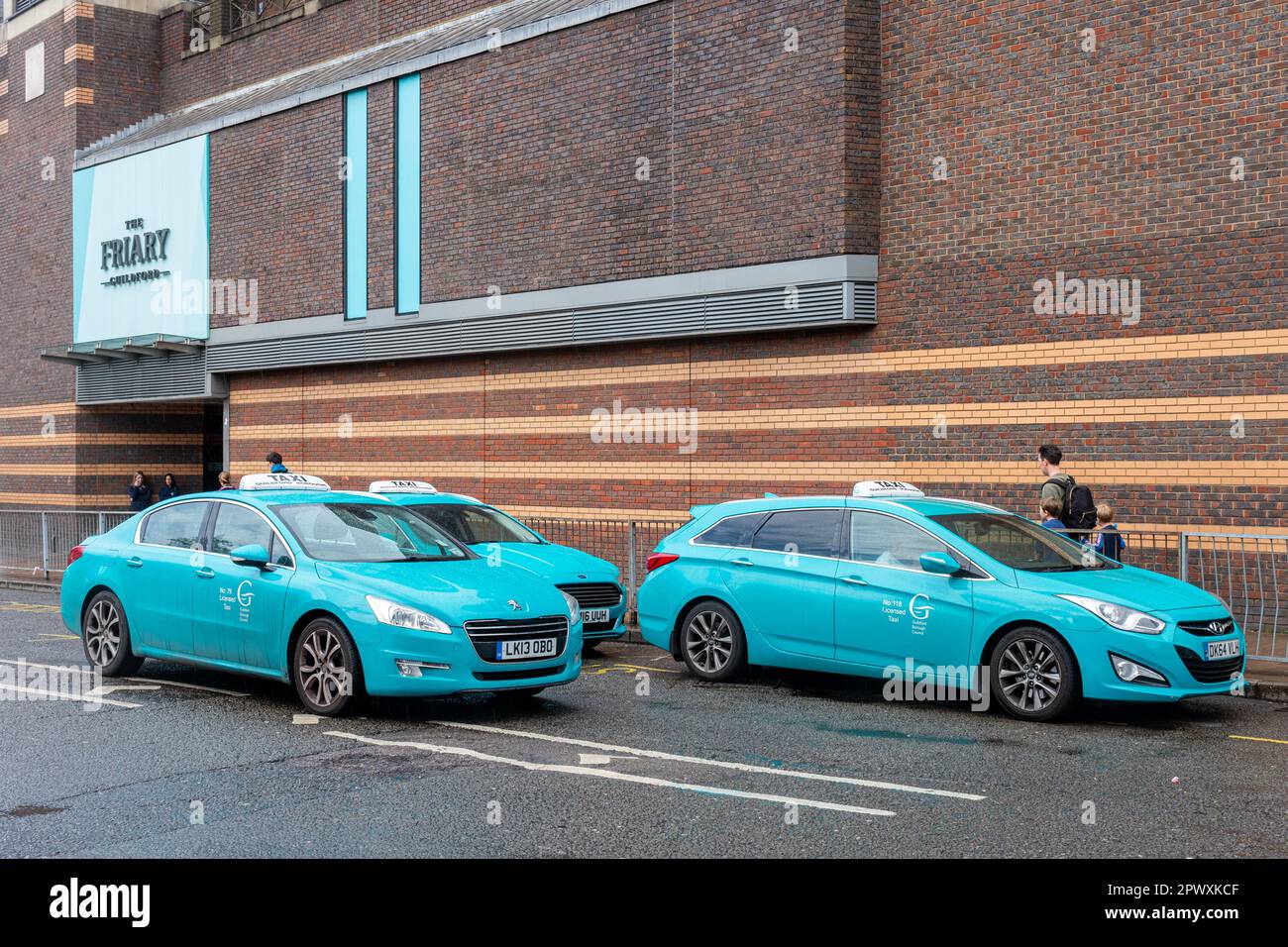 Guildford Borough Council taxis outside the Friary shopping centre, turquoise cars, teal livery, Surrey, England, UK, 2023 Stock Photo