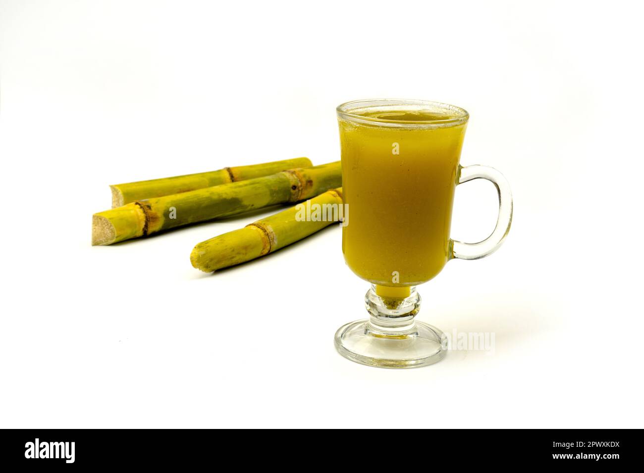Fresh squeezed sugar cane juice with fresh cane sliced isolated on