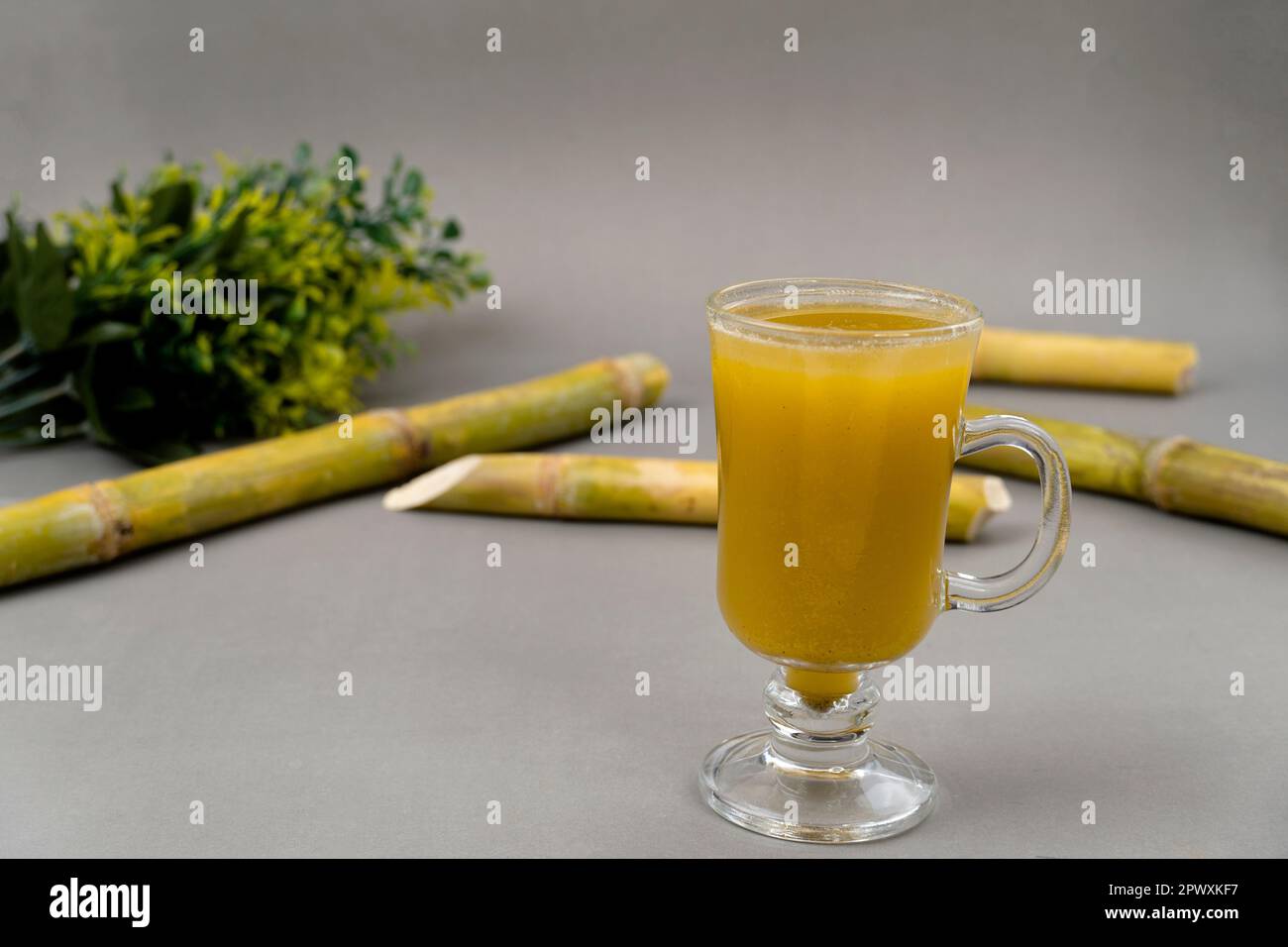 Fresh squeezed sugar cane juice with fresh cane sliced isolated on
