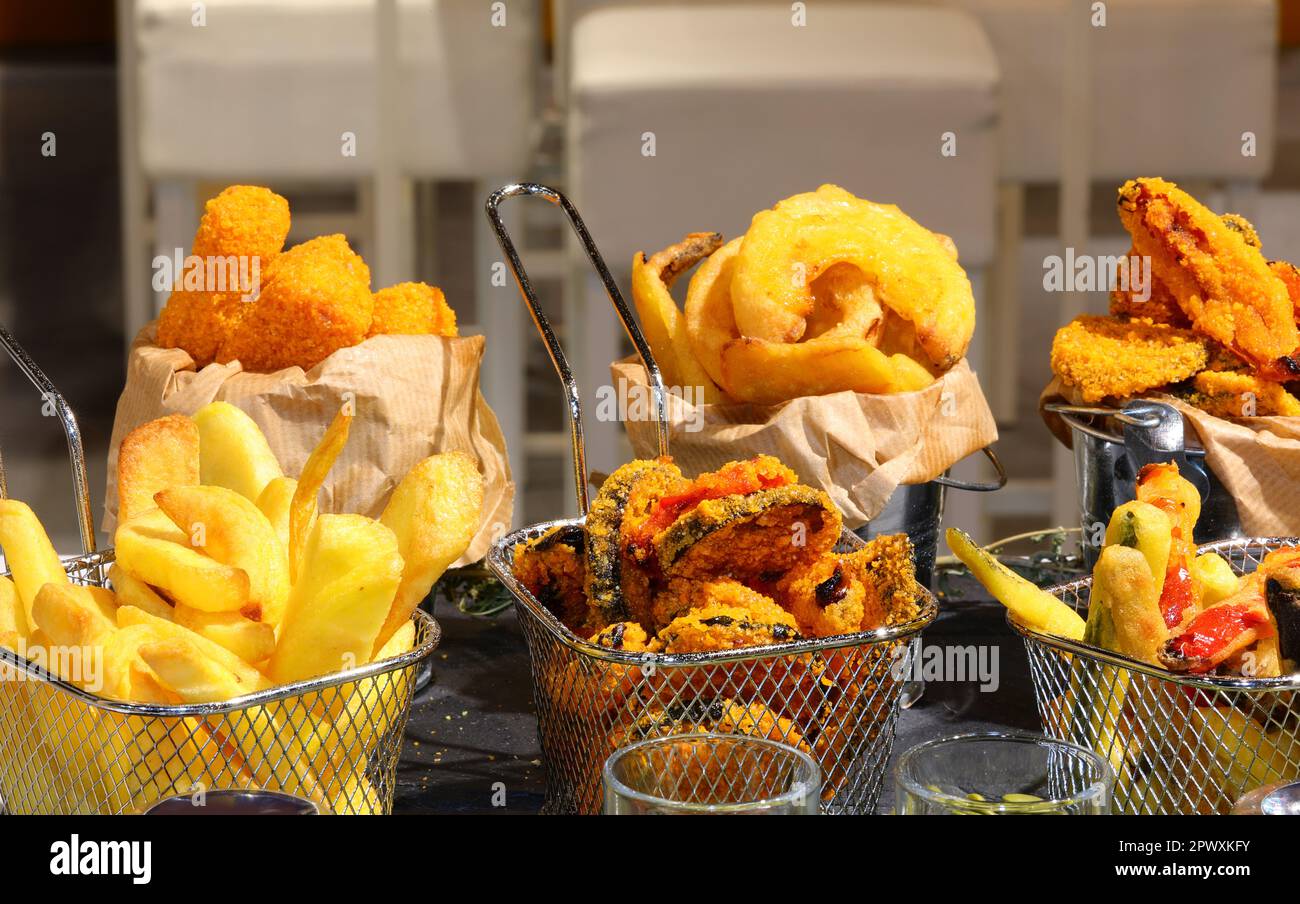 trays of mixed fried with battered vegetables and french fries for sale