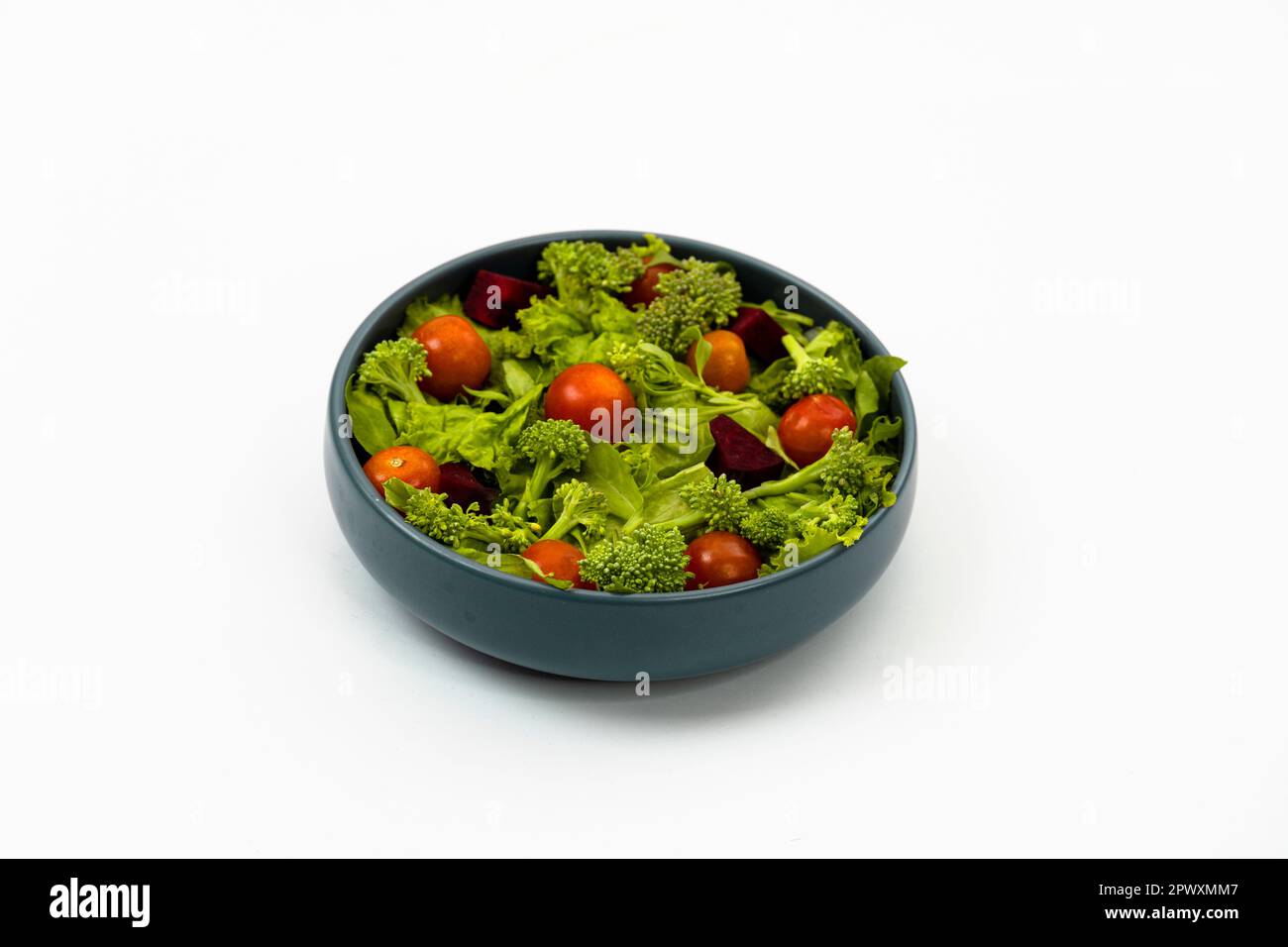 Green vegan salad from green leaves mix and vegetables on white background. Stock Photo