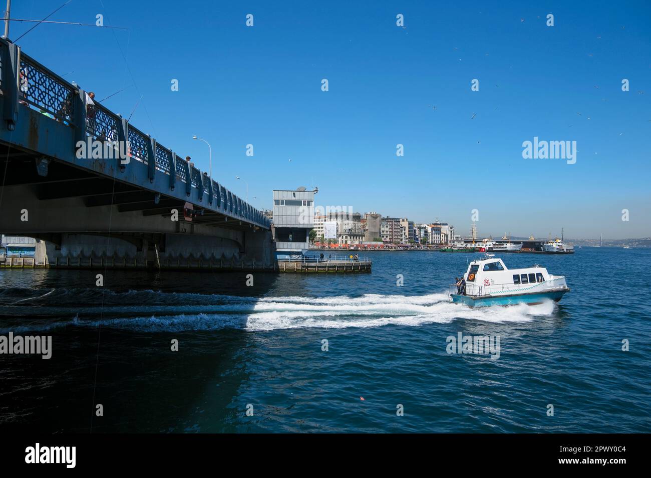 Istanbul, Turkey - May, 2022. Ferry boat on sea with buildings in background against sky with Galata Bridge at Istanbul, Turkey Stock Photo