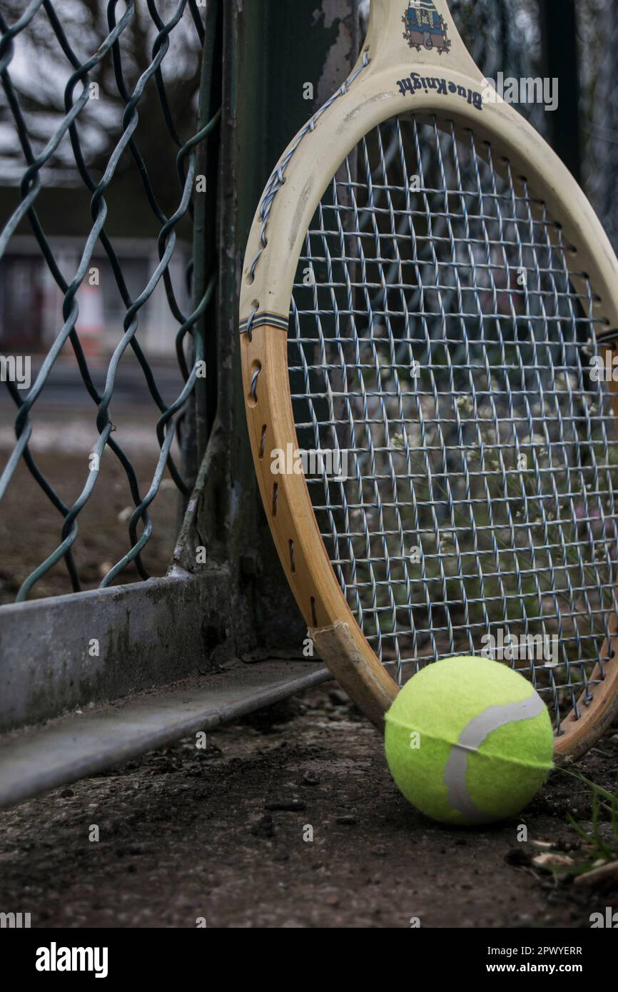 tennis ball and racket against a court fence Stock Photo Alamy