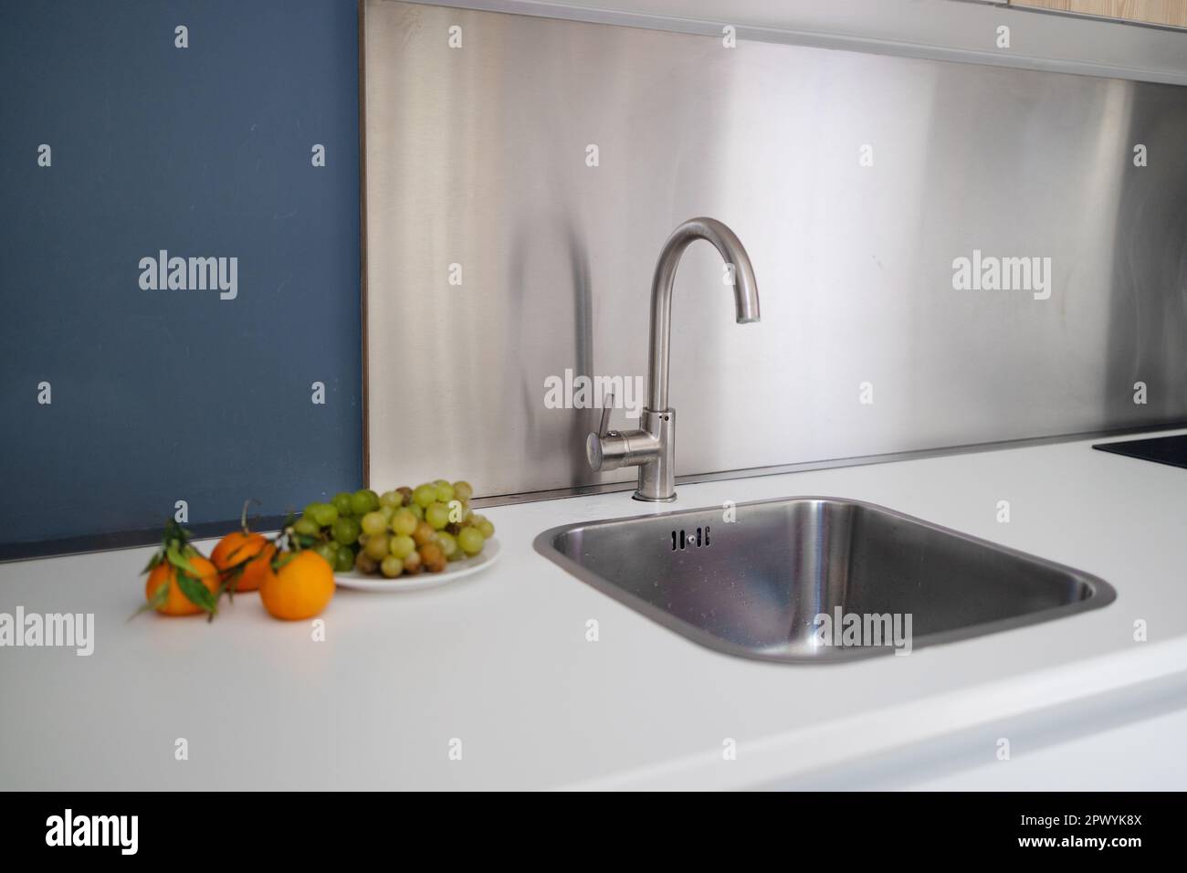 Metal kitchen sink and tap water in the kitchen. Interior of the