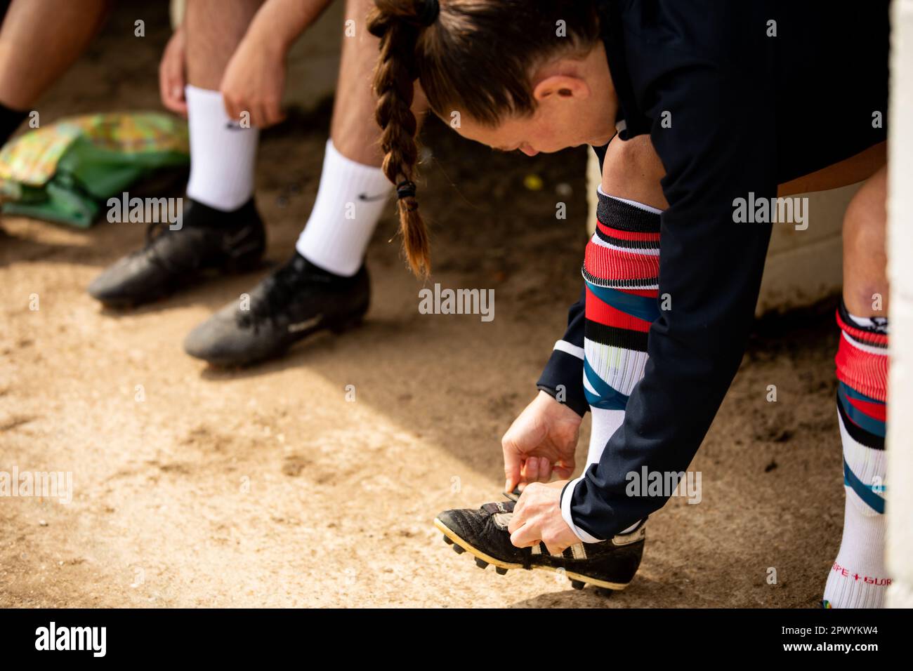Female football player tying boot laces Stock Photo Alamy