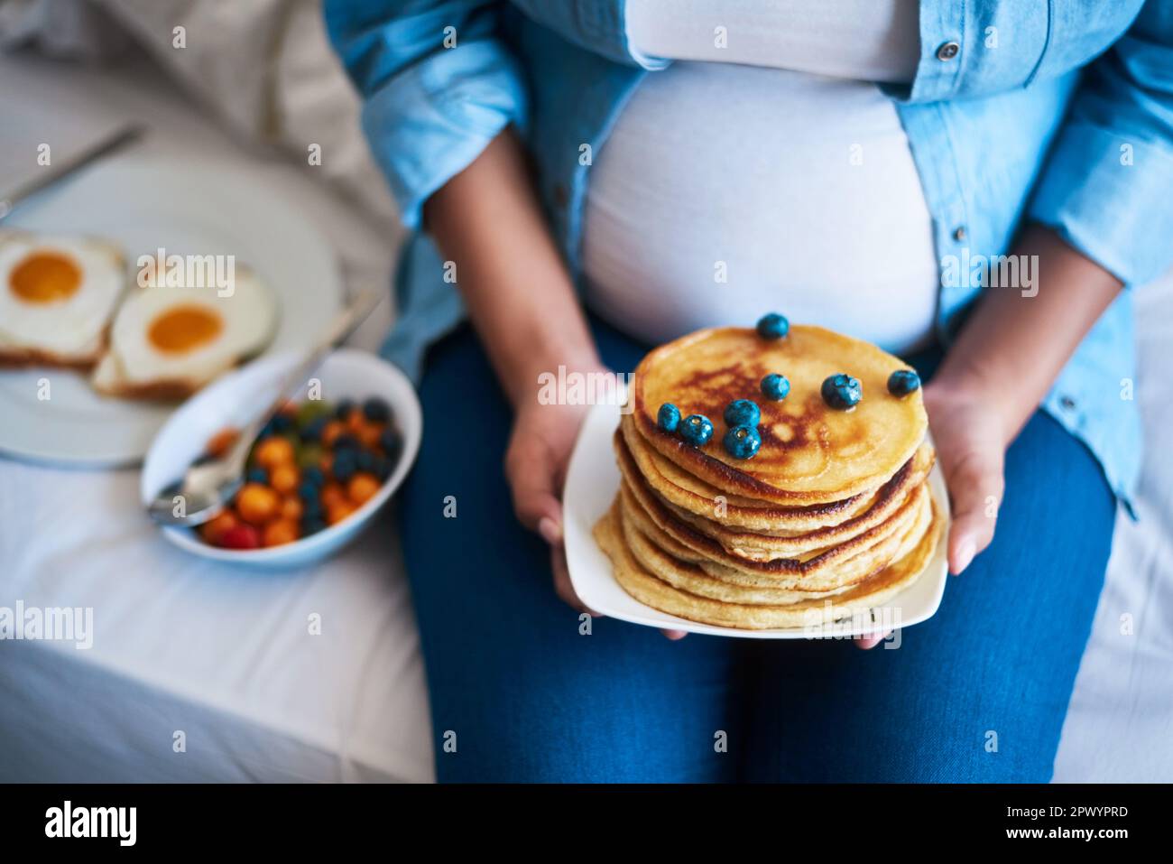 The baby ordered something sweet off the menu. a pregnant woman eating