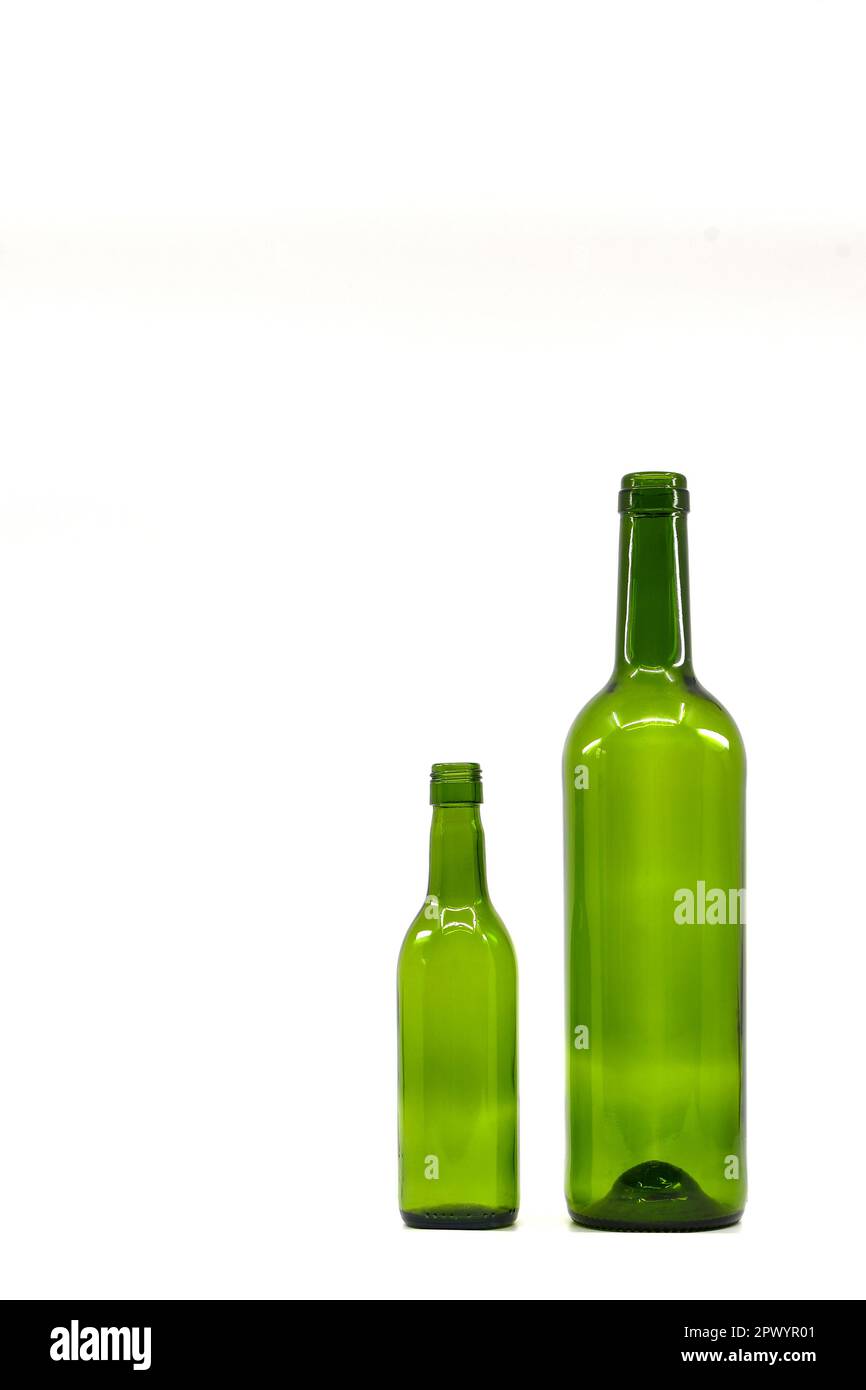 One full size and one quarter empty green wine bottles standing side by side. Isolated on a plain white background. Contrast. Stock Photo