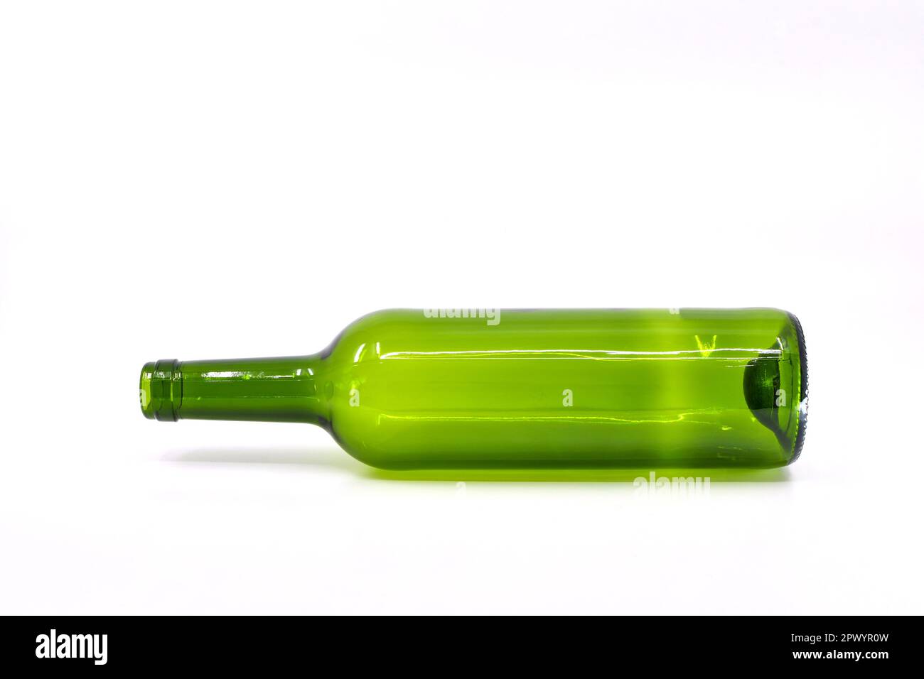 Empty green wine bottle lying on its side against a plain white background Stock Photo