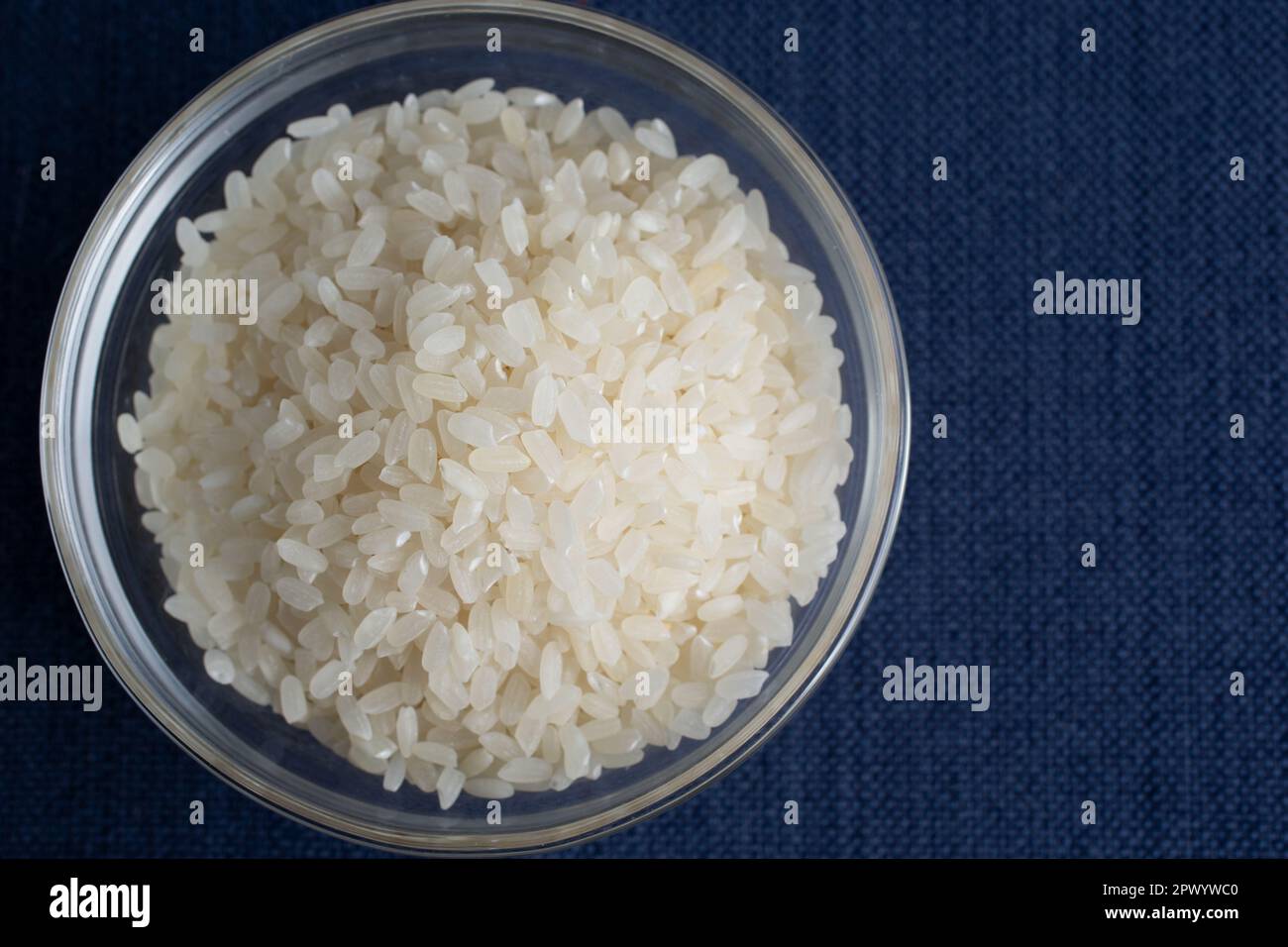A top down view of a glass bowl of short grain rice. Stock Photo