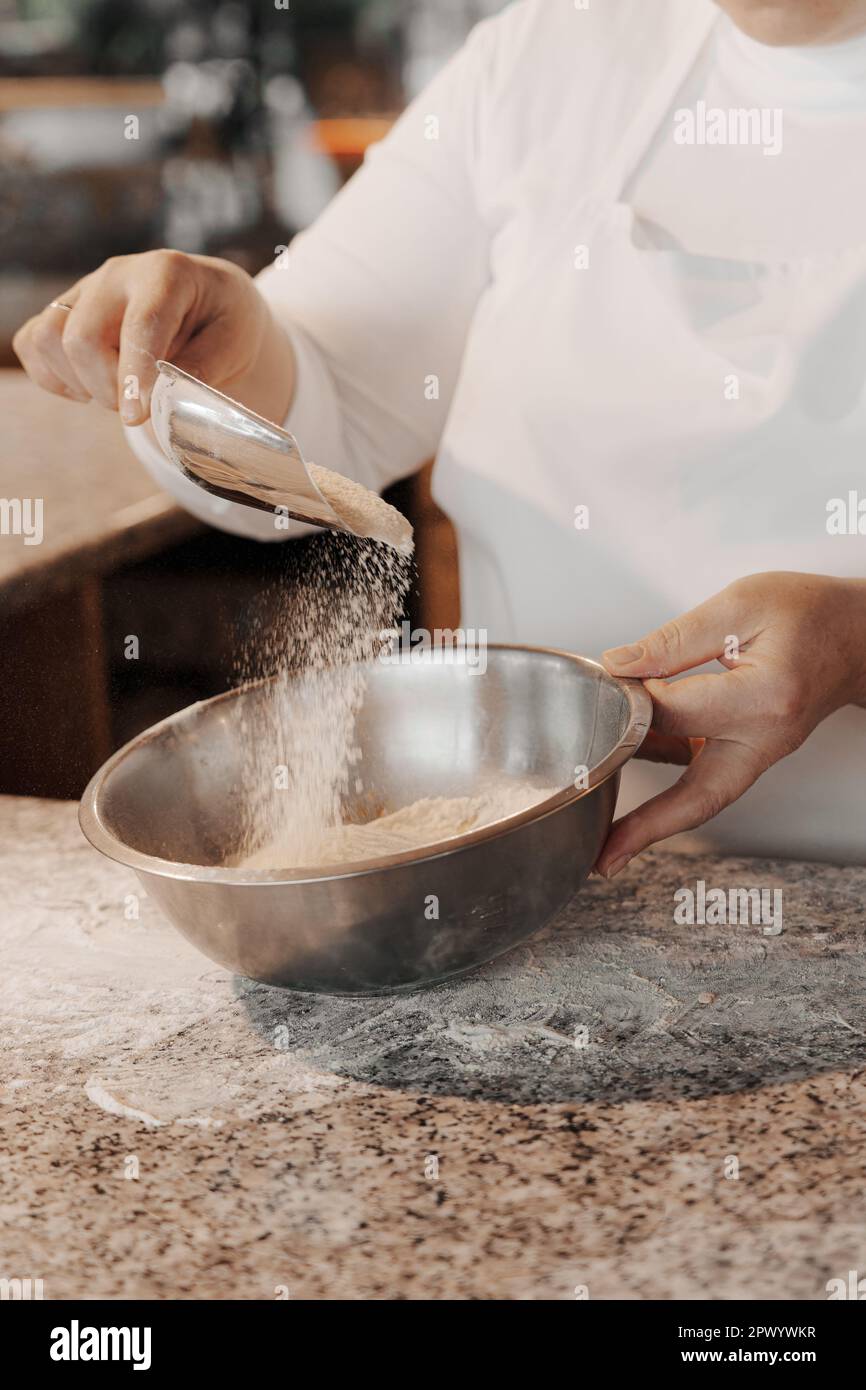 Crop woman adding flour into bowl Stock Photo Alamy
