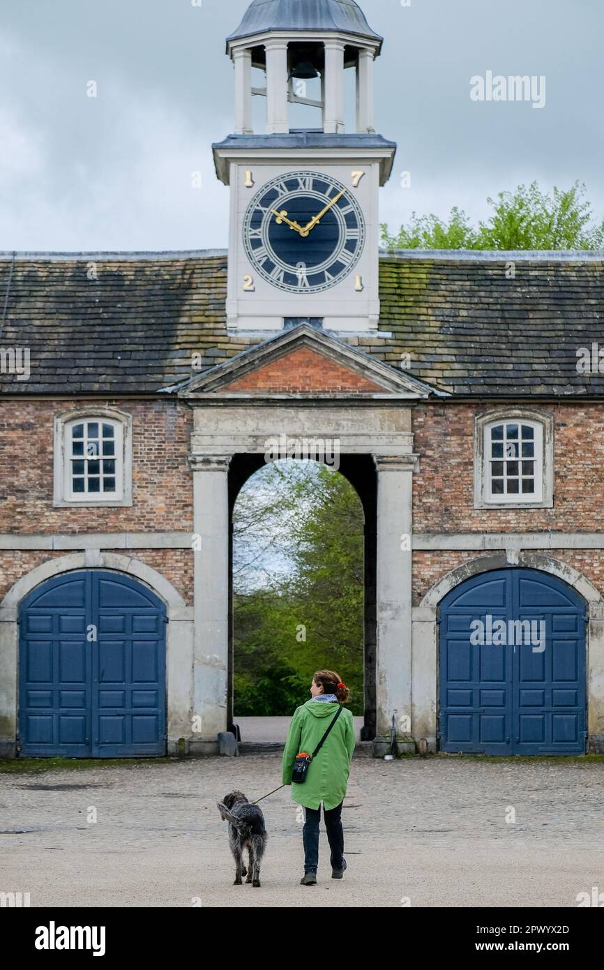A visitor and dog at Dunham Massey Hall and Gardens, Altrincham, is