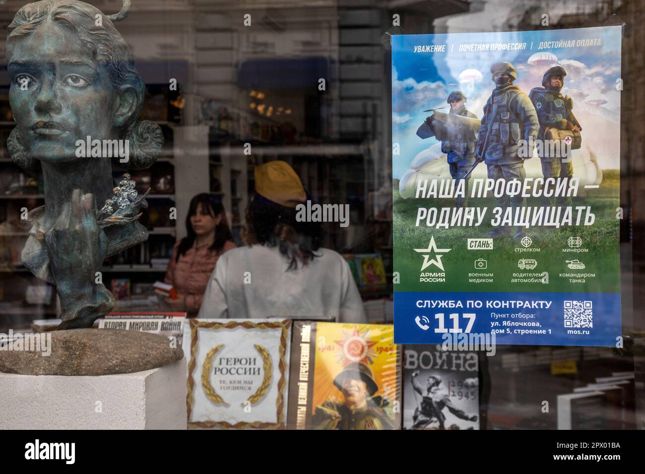 Moscow, Russia. 1st of May, 2023. A poster promoting contract army service and reading 'Our job, defending the homeland' adorns a window of a book shop in central Moscow, Russia Stock Photo
