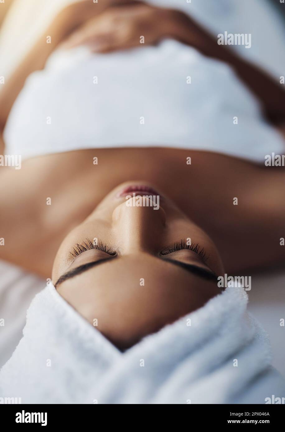 Youre in the no-stress zone now. a young woman relaxing on a massage table at a spa Stock Photo