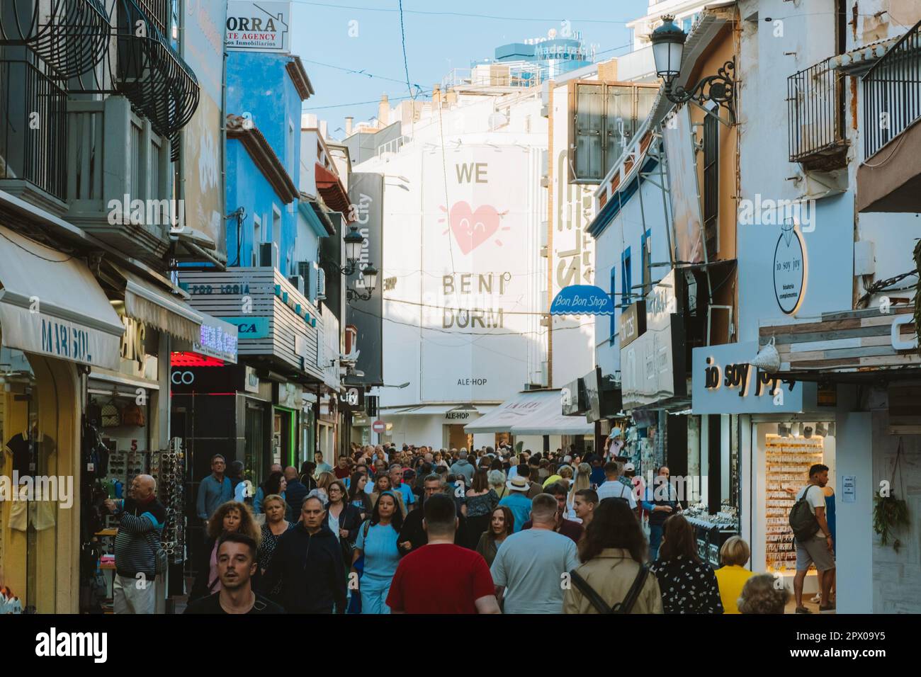 Benidorm, Spain - 01 April, 2023: People walking and enjoy sunny day on the shopping street in Benidorm old town. Crowdy streets of Benidorm. Benidorm Stock Photo