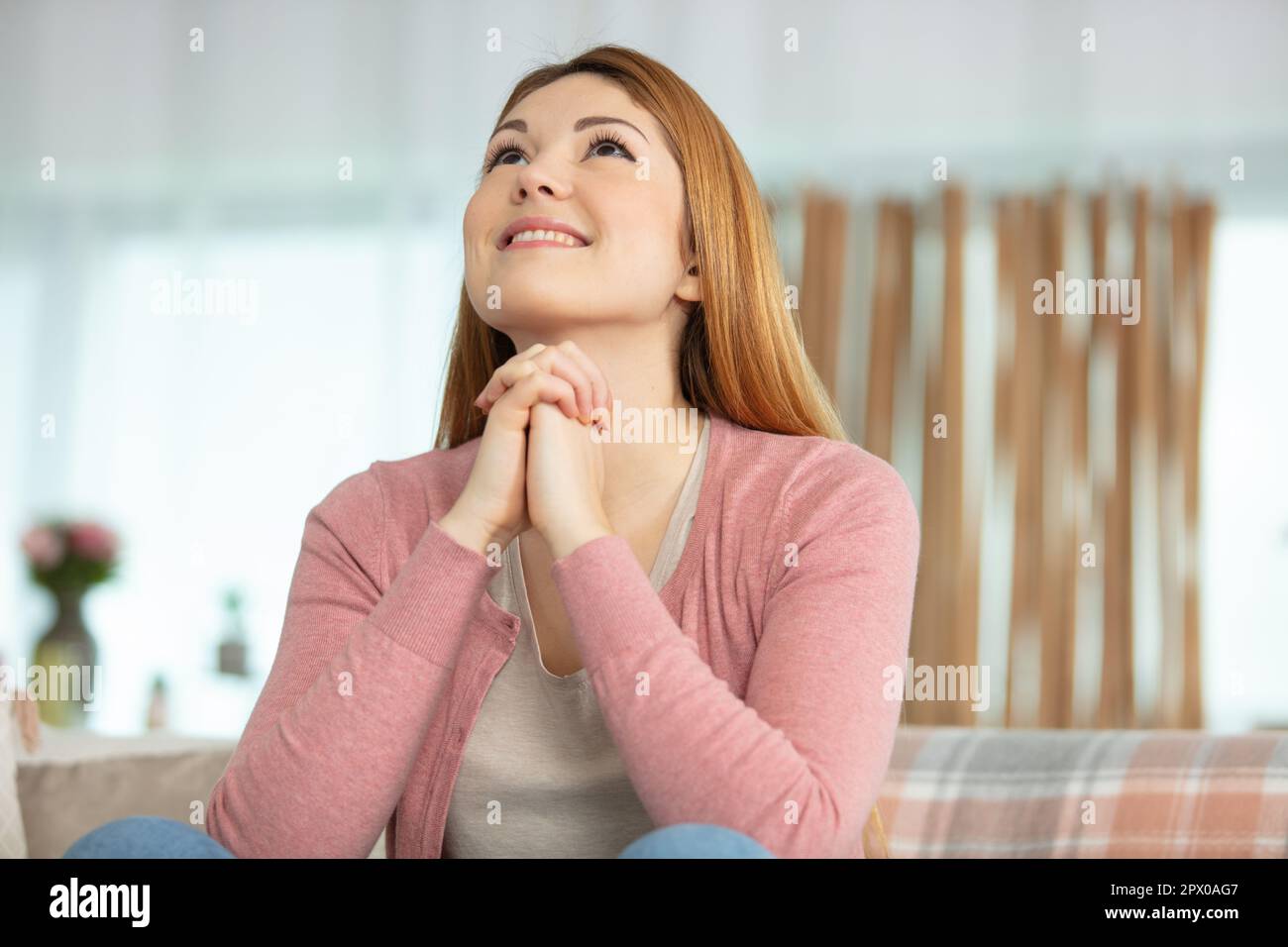 close up focus on happy sincere female holding folded hands Stock Photo