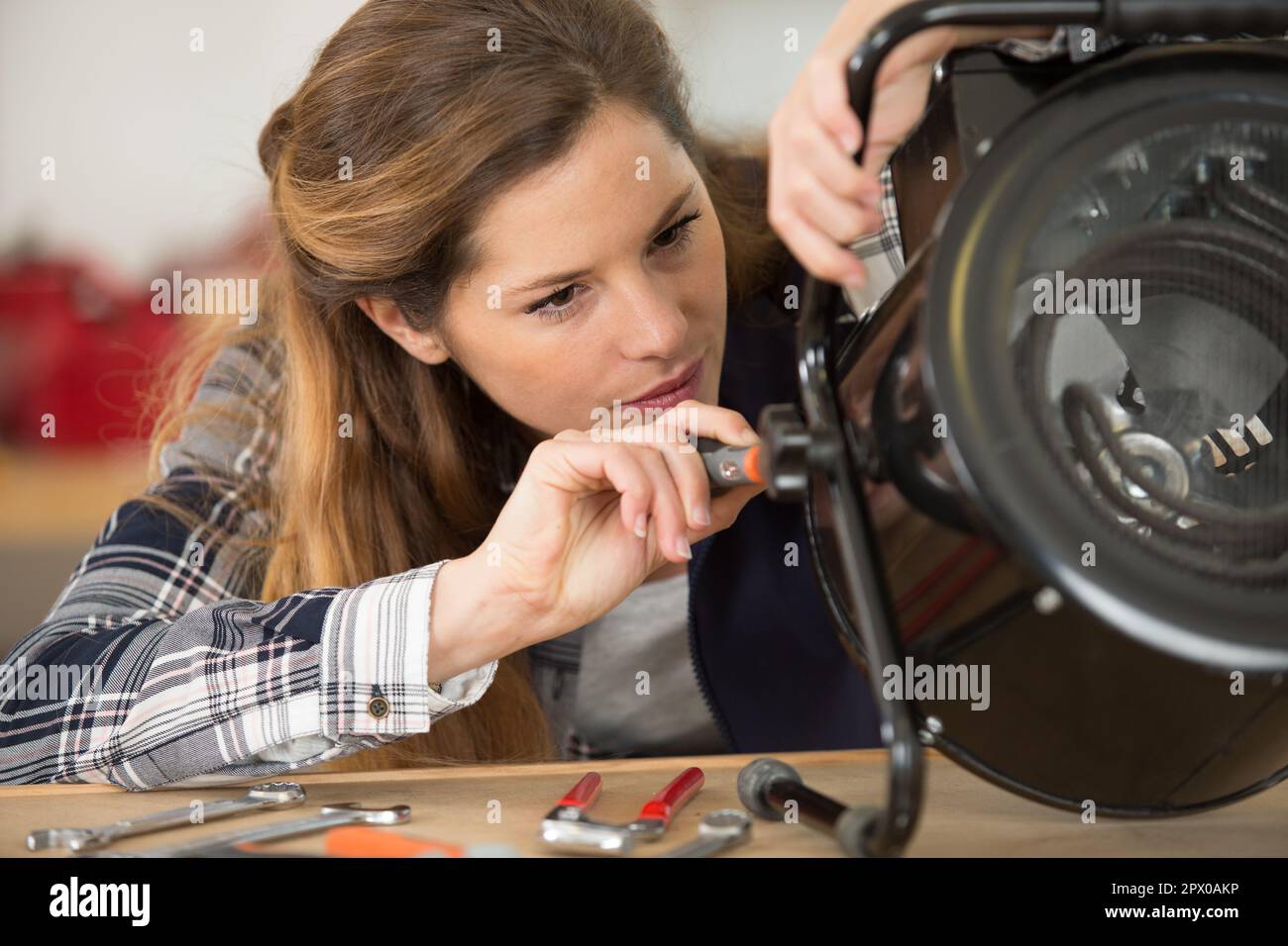 female engineer repairing portable heater Stock Photo