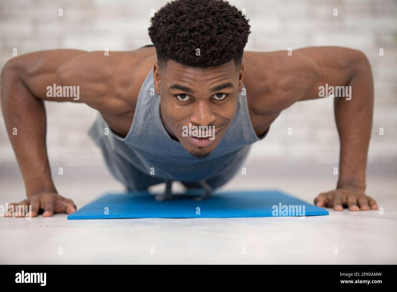 fitness guy training on exercise mat in his own livingroom Stock