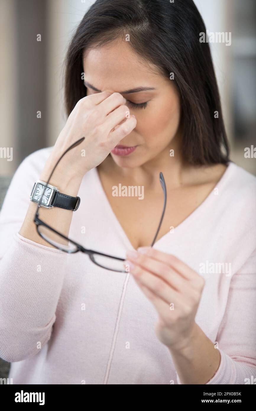 woman with glasses rubbing her eyes feel tired Stock Photo Alamy