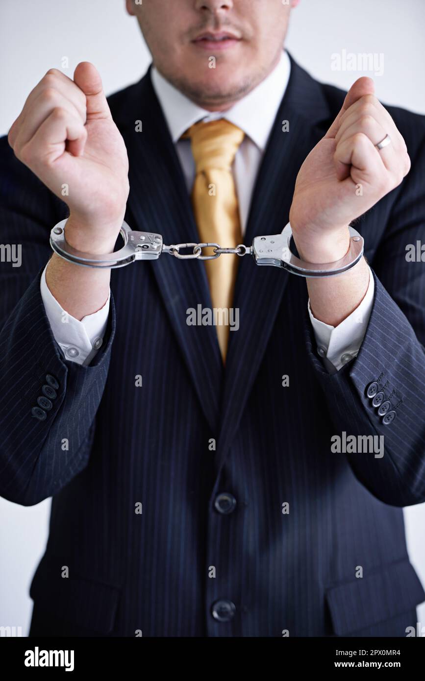 Brought to justice. a businessman wearing handcuffs. Stock Photo