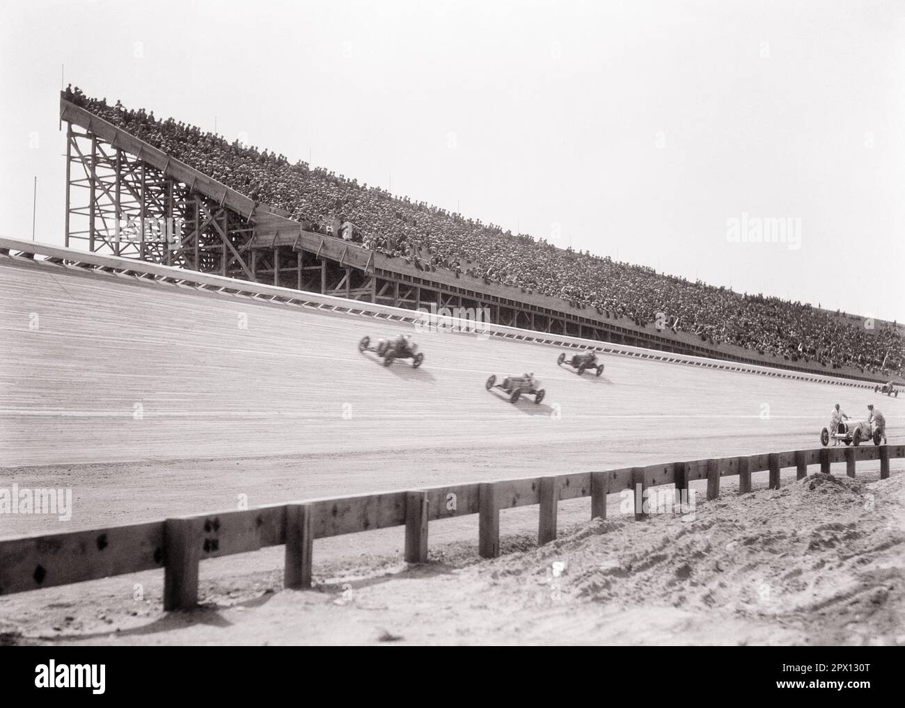 1930s THREE MIDGET RACE CARS ON SLANTED TRACK SPEEDING PAST CROWD MEN AND WOMEN WATCHING IN LARGE SLOPED WOODEN GRANDSTAND - m915 HAR001 HARS FEMALES ASSEMBLY RURAL COPY SPACE LADIES MASS PERSONS AUTOMOBILE MALES ATHLETIC ENTERTAINMENT TRANSPORTATION SPECTATORS B&W GATHERING WIDE ANGLE ADVENTURE DANGEROUS AND AUTOS EXCITEMENT RECREATION INNOVATION IN ON ATTRACTION OCCUPATIONS PAST SPEEDING PROFESSIONAL SPORTS CONCEPTUAL GRANDSTANDS AUTOMOBILES VEHICLES GRANDSTAND PANORAMIC RACEWAY SLOPED MIDGET THRONG ATTENDANCE BLACK AND WHITE HAR001 OLD FASHIONED Stock Photo