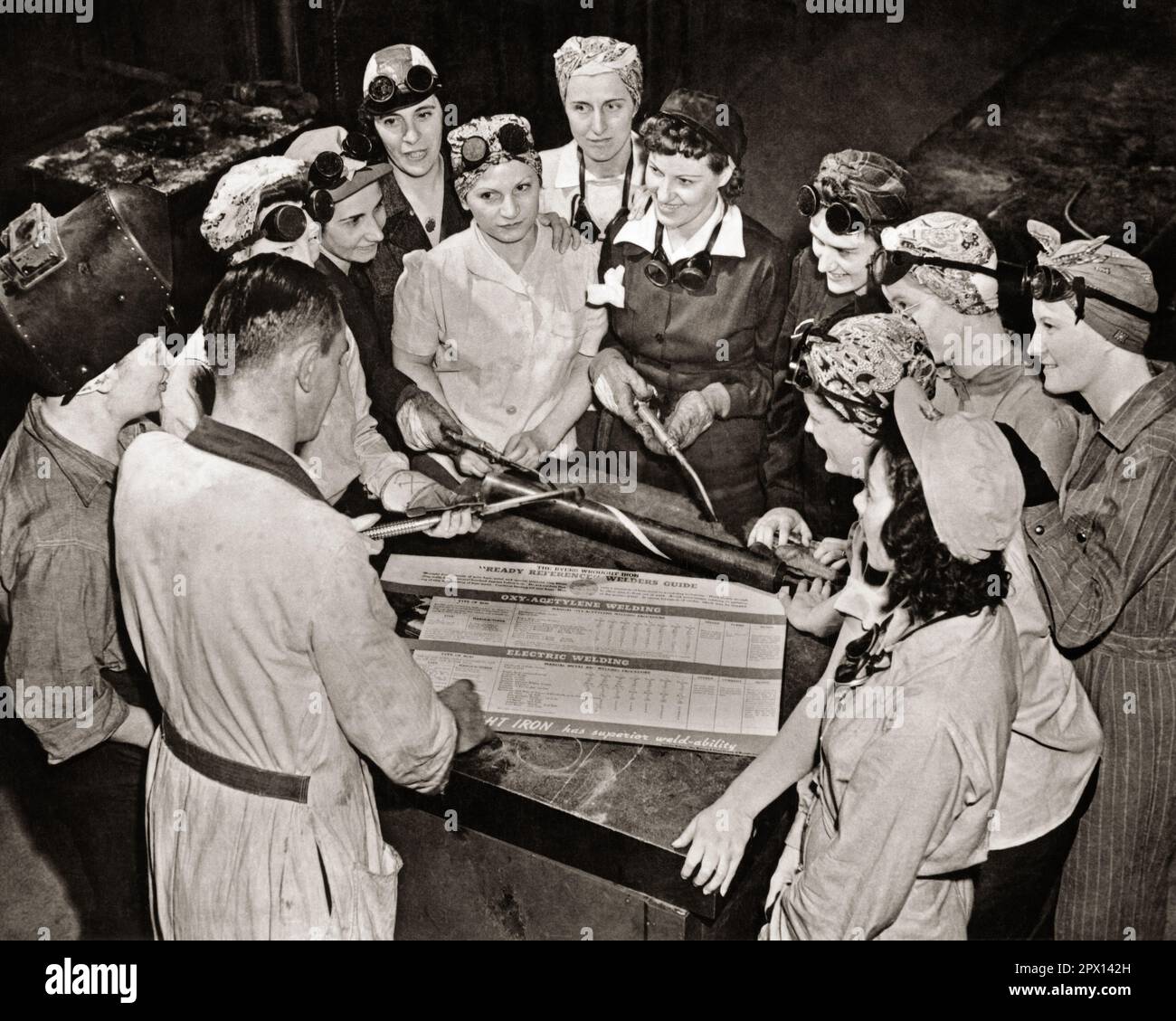 1940s WOMEN IN A WELDING CLASS AT THE BEGINNING OF WORLD WAR 2 HOPING TO SPEED PRODUCTION AND ASSIST IN THE WAR EFFORT  - q6154 CPC001 HARS CONFLICT FEMALES WW2 JOBS COPY SPACE HALF-LENGTH LADIES PERSONS GOGGLES MALES CONFIDENCE B&W SKILL OCCUPATION SKILLS HOME FRONT HIGH ANGLE ADVENTURE AND EFFORT EXCITEMENT WORLD WARS LABOR PRIDE WORLD WAR WORLD WAR TWO WORLD WAR II OPPORTUNITY EMPLOYMENT FEMININE OCCUPATIONS WARTIME WELDING HOPING HEAD SCARF FEMINISM WORLD WAR 2 ASSIST EMPLOYEE WELDERS COOPERATION DEFENSE BEGINNING BLACK AND WHITE CAUCASIAN ETHNICITY LABORING OLD FASHIONED WORK CLOTHES Stock Photo