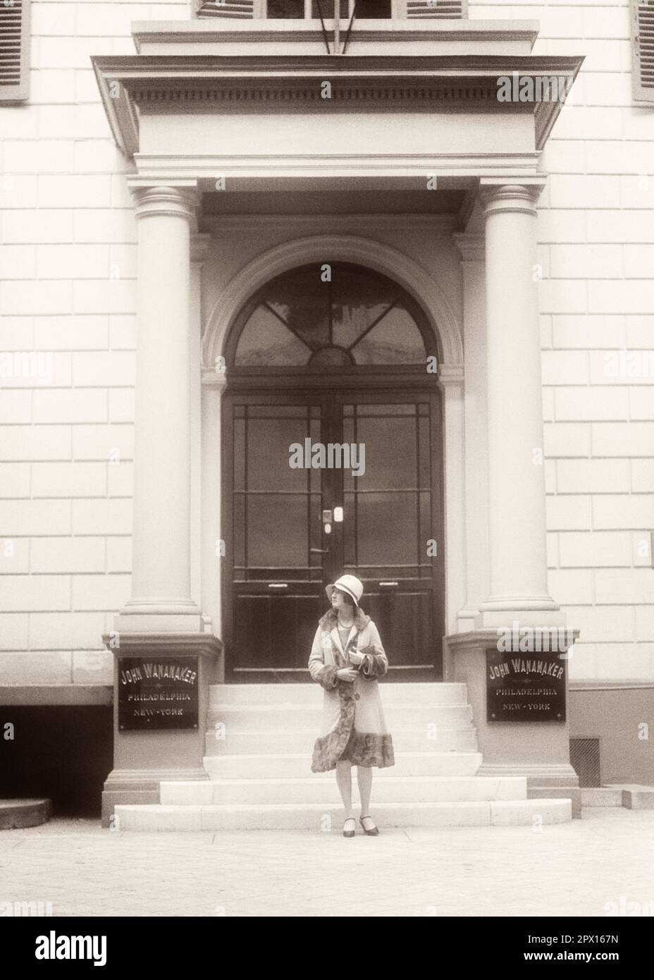 1920s FASHIONABLY DRESSED WOMAN TOURIST STANDING ON OFFICE STEPS OF JOHN WANAMAKER COMPANY DEPARTMENT STORE PARIS FRANCE - r2585 HAR001 HARS LUXURY COPY SPACE FULL-LENGTH LADIES PERSONS INSPIRATION BUILDINGS EUROPE B&W SHOPPER SHOPPERS HAPPINESS ADVENTURE DISCOVERY EUROPEAN LEISURE PROPERTY STYLES EXTERIOR LOW ANGLE TOURIST REAL ESTATE FASHIONABLY STRUCTURES COMPANY STYLISH EDIFICE FASHIONS WANAMAKER YOUNG ADULT WOMAN BLACK AND WHITE CAUCASIAN ETHNICITY HAR001 OLD FASHIONED Stock Photo