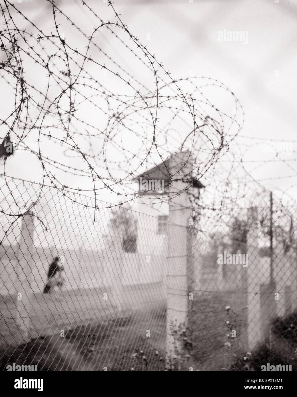 1970s SHOT OF BARBED WIRE FENCE AT CONCENTRATION CAMP DACHAU BAVARIA SOUTH GERMANY  - s19017 HAR001 HARS MURDER ROMANI 1933 BLACK AND WHITE CONCRETE COUNTRIES HAR001 OLD FASHIONED Stock Photo
